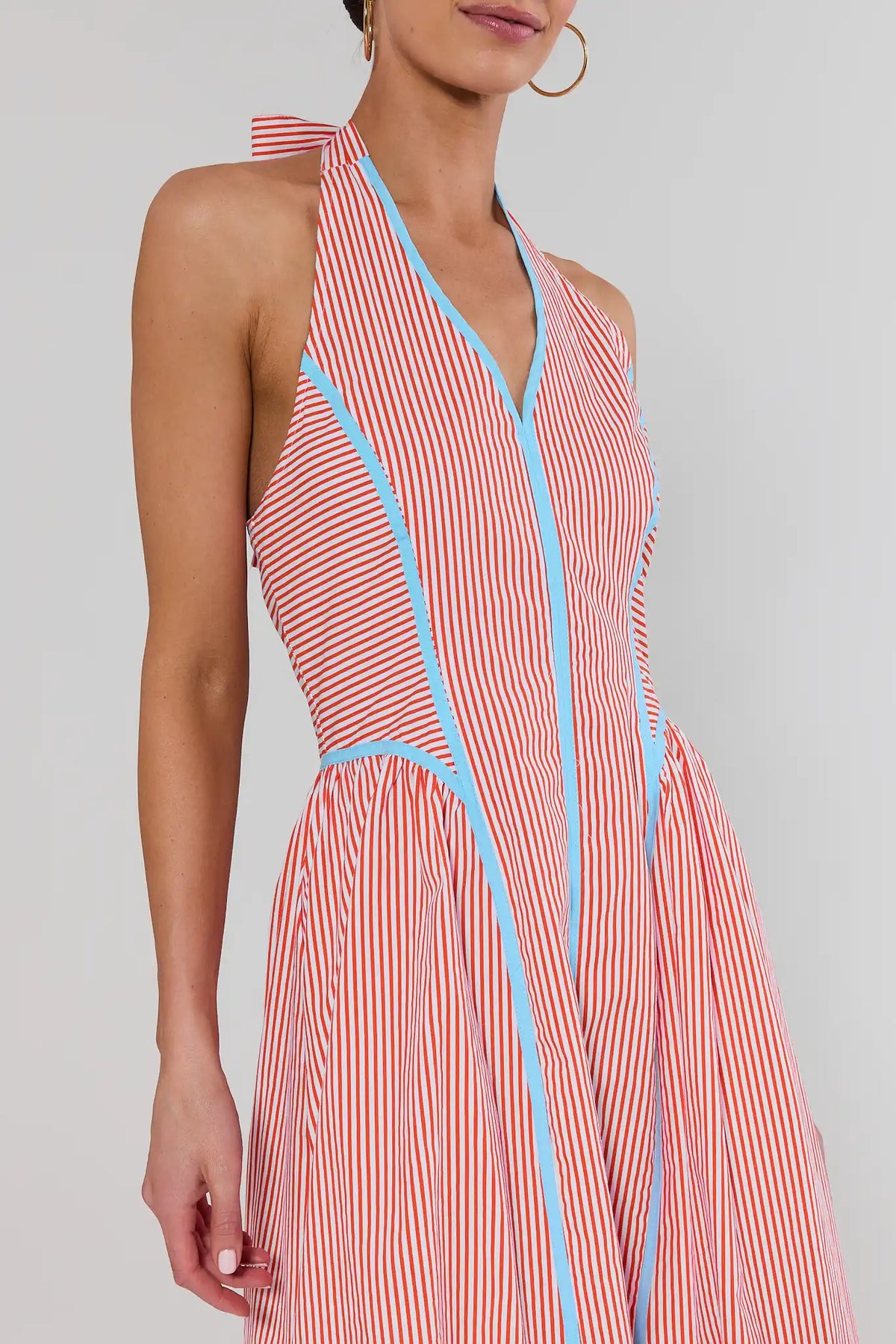 close up Red and white striped dress with blue accents on a plain background
