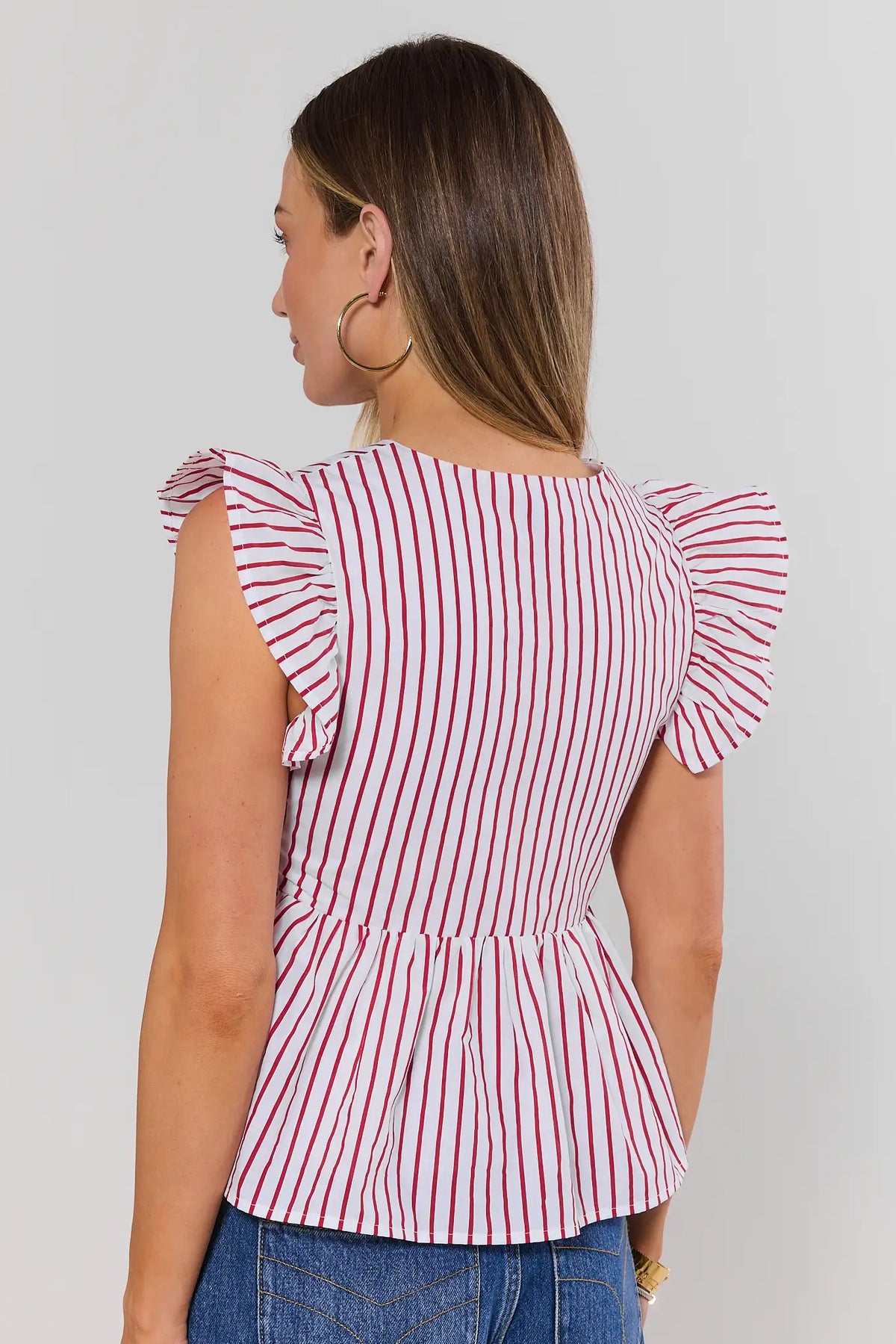 Red striped flutter sleeve peplum top back view showing ruffle sleeves and flared hem on model | Avara