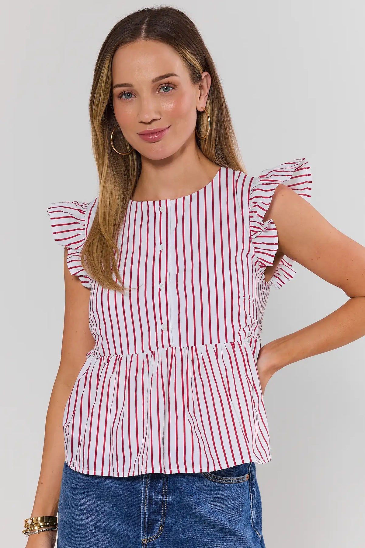 Red striped flutter sleeve peplum top with button front, on model front view paired with blue denim | Avara