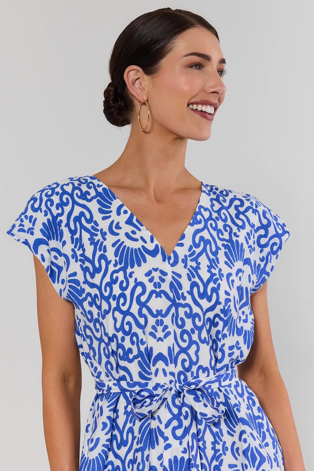 Close-up of blue printed midi dress with V-neckline, cap sleeves, and tie waist detail - Neckline View | Avara