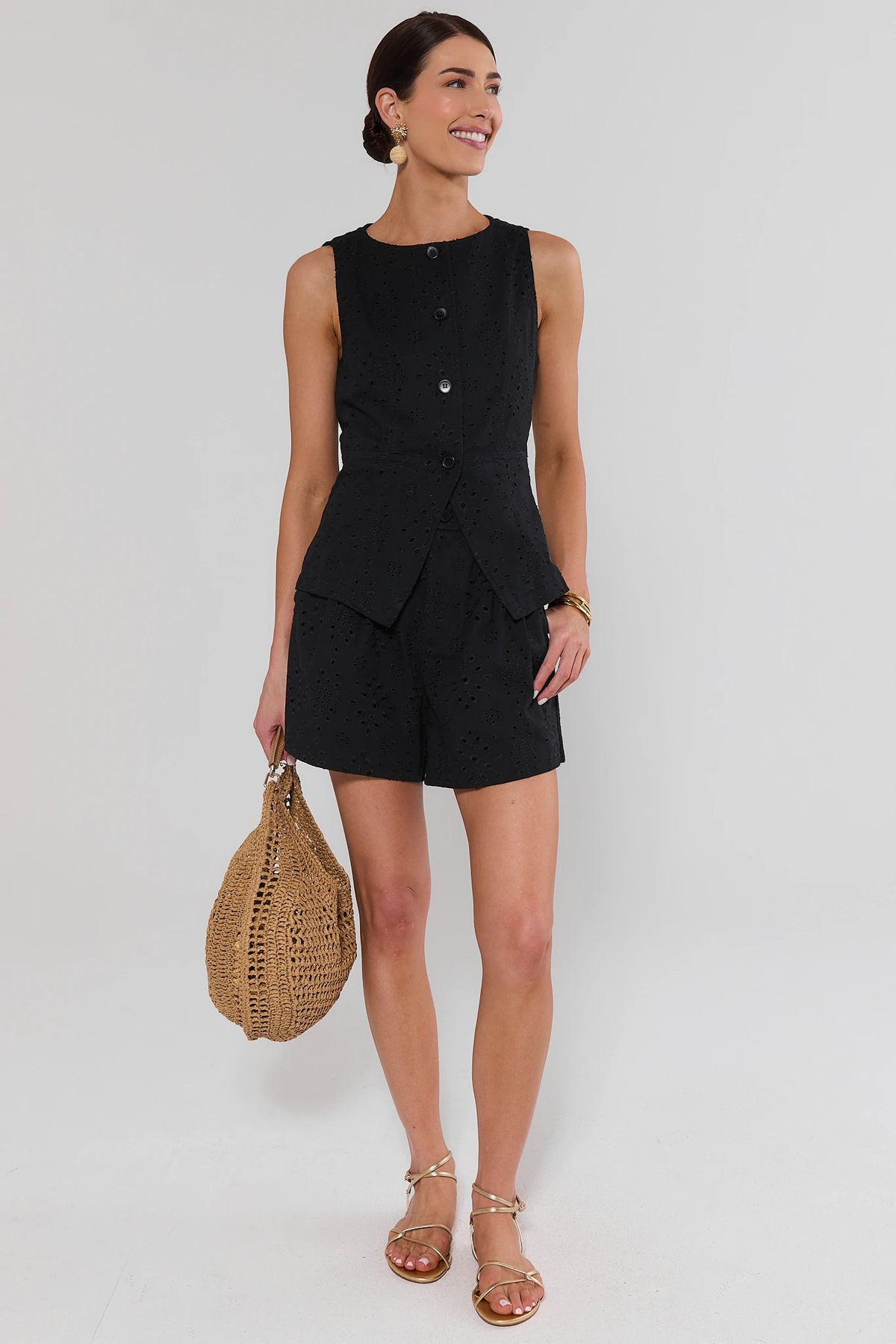 Black eyelet tailored shorts styled with matching button-up vest and woven bag - Full Outfit View | Avara