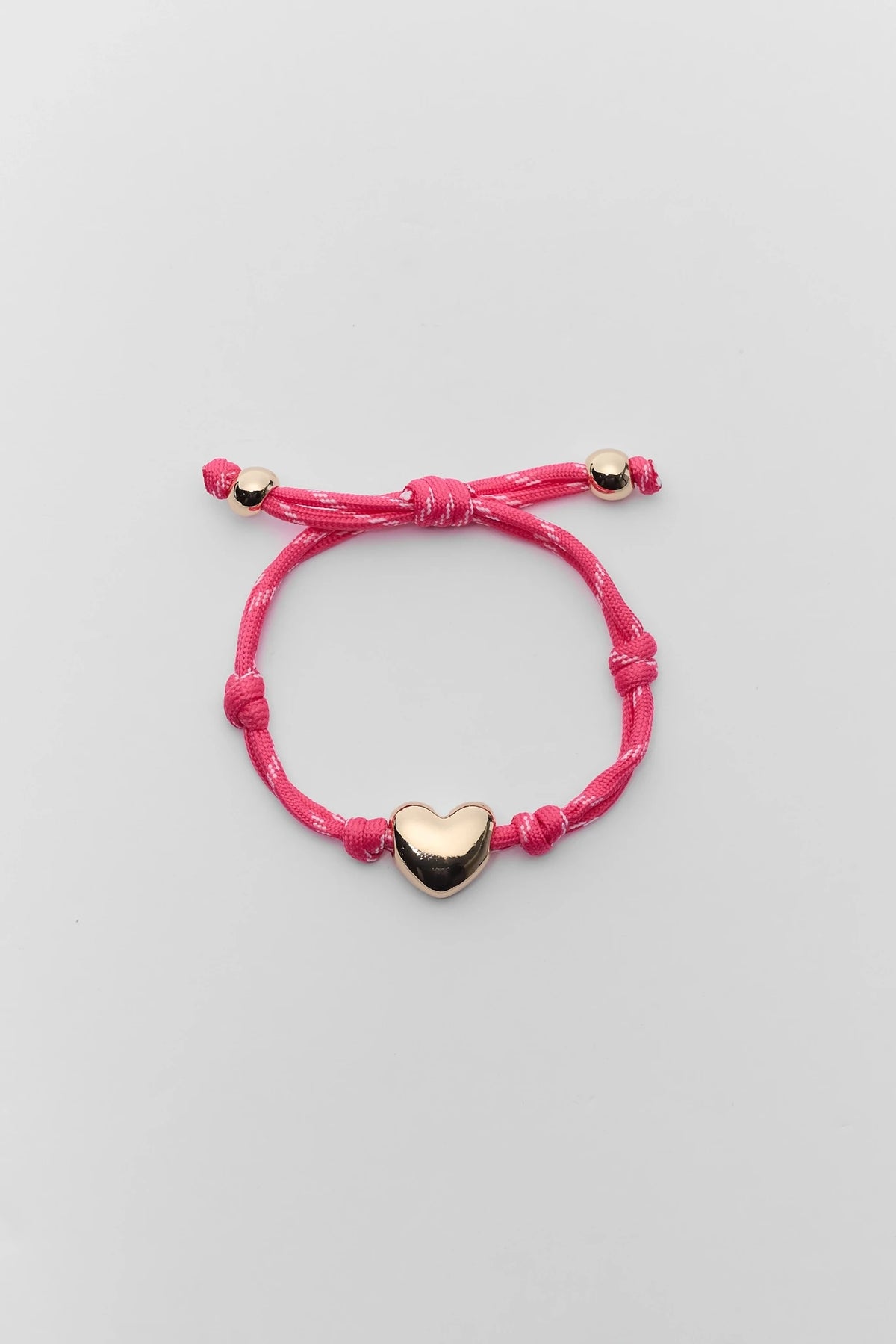 Pink paracord heart charm bracelet with gold-tone hardware - Flat Lay | Avara
