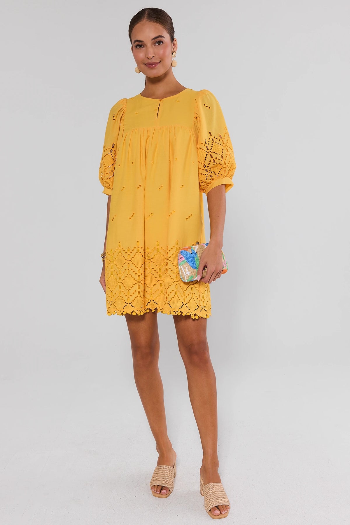 Yellow Eyelet Mini Dress styled with woven mules and beaded clutch - Full Length On Model | Avara