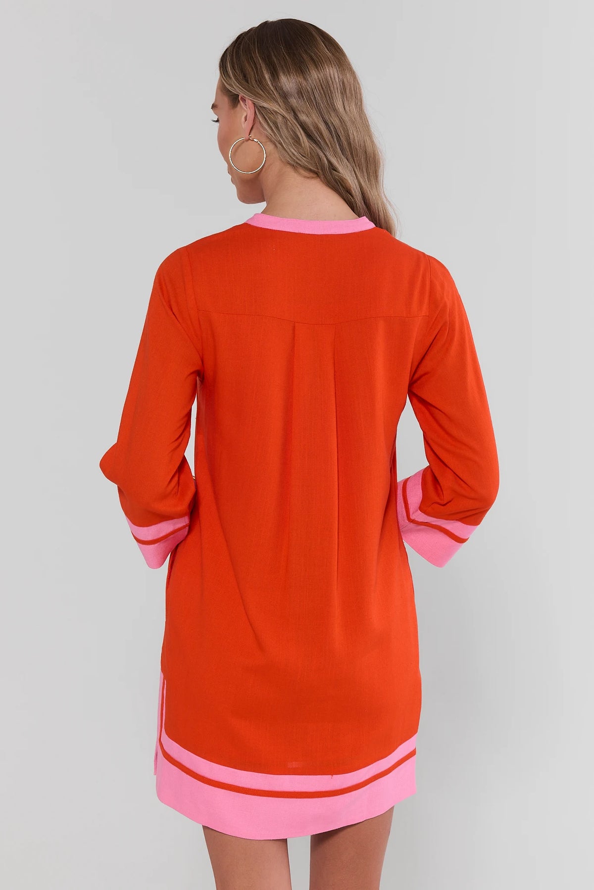 Orange tunic short dress with pink trim and 3/4 sleeves, back view showing relaxed silhouette | Avara