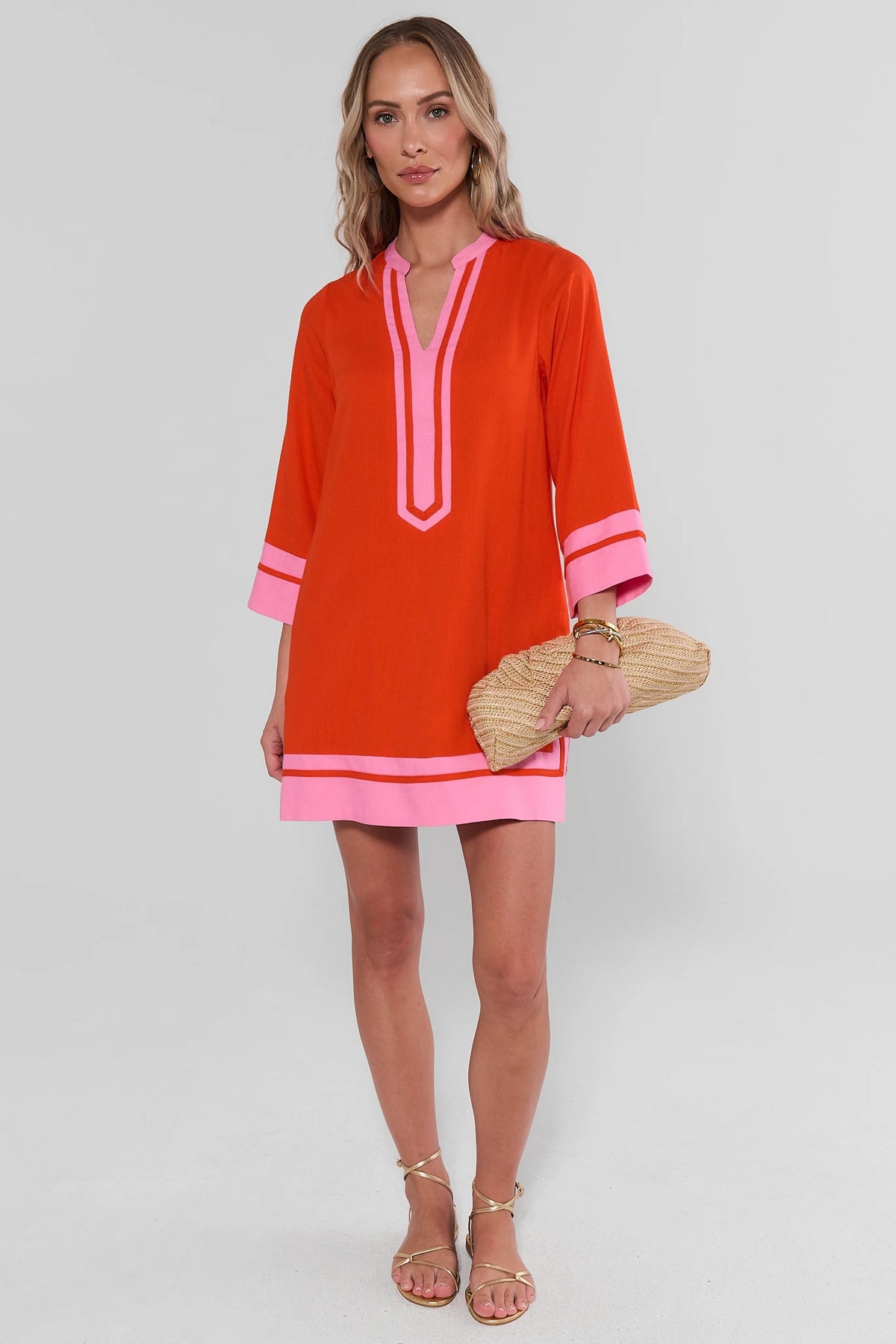 Orange contrast trim tunic short dress full-length on model with gold sandals and woven clutch | Avara