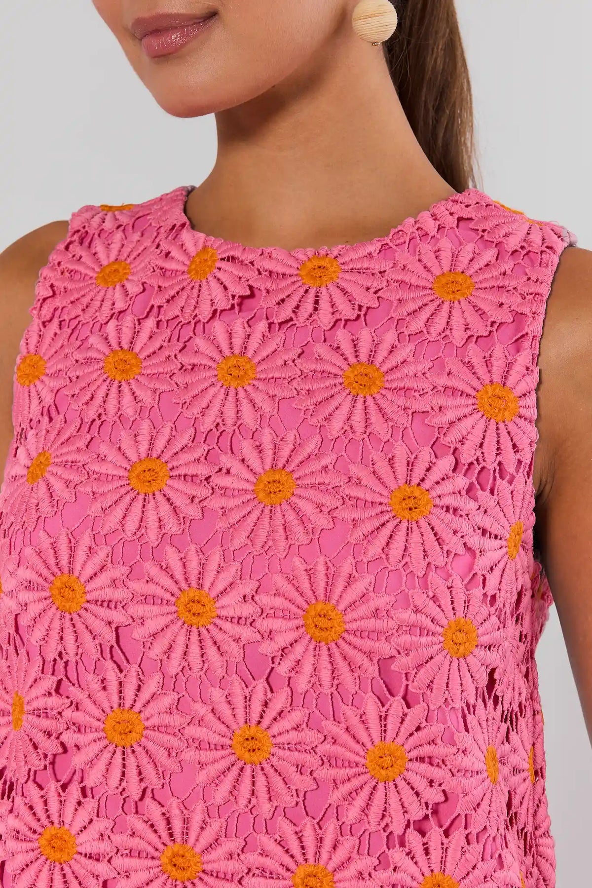 Pink floral overlay dress close-up showing orange daisy crochet lace detail and round neckline | Avara