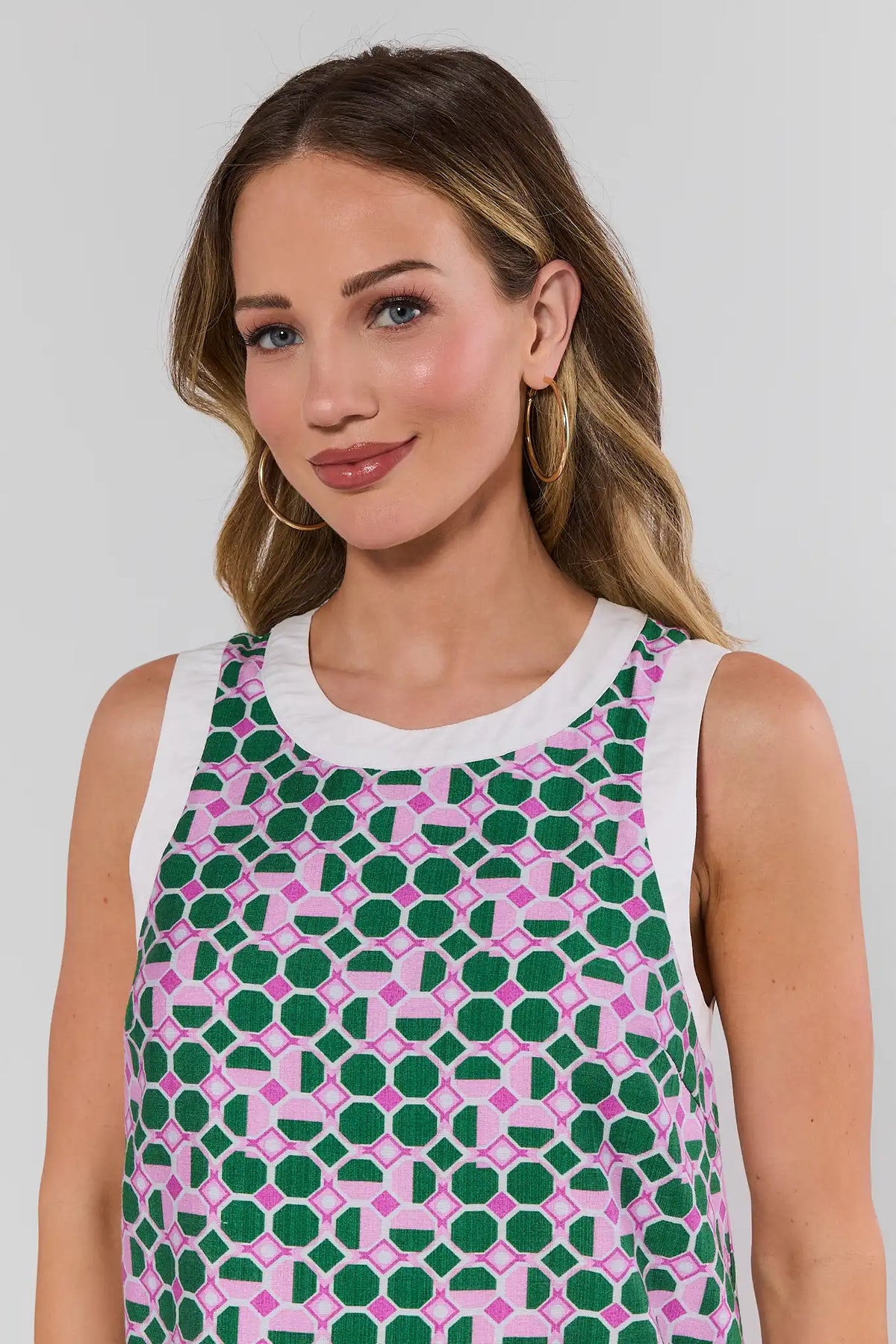 Close-up of green pink geometric print mini dress with white contrast trim neckline detail - On Model | Avara