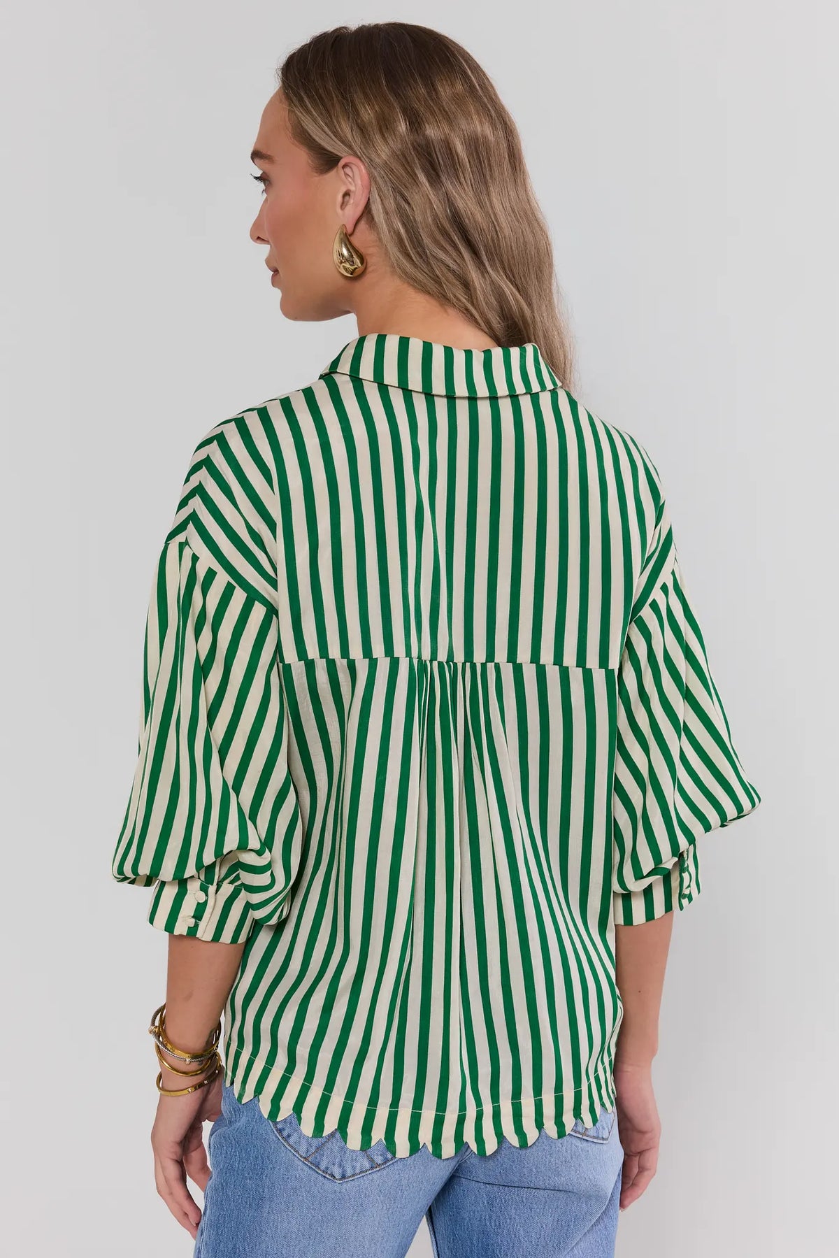 Green striped women's top with gathered back detail and scalloped hem over jeans - Back View | Avara