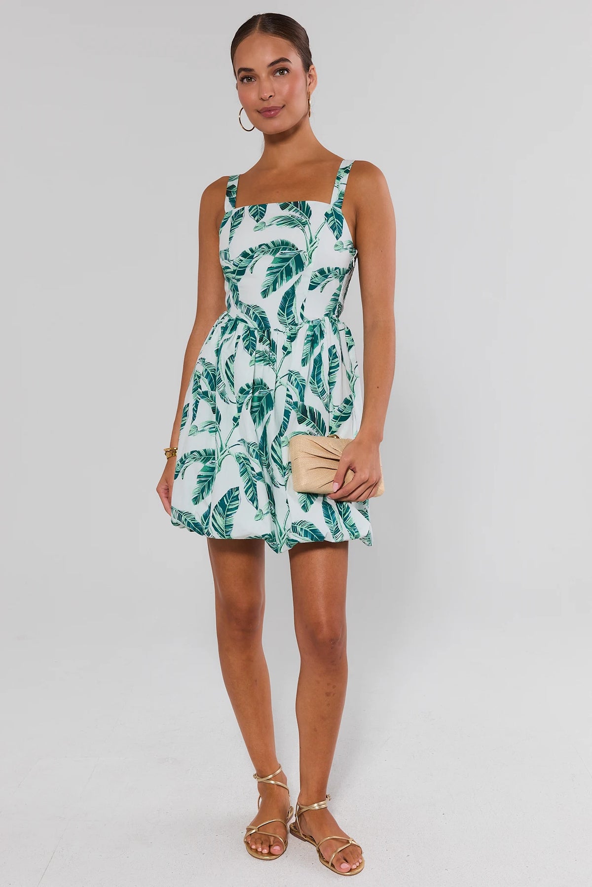 White palm print bubble short dress styled with gold sandals and woven clutch, full-length view | Avara