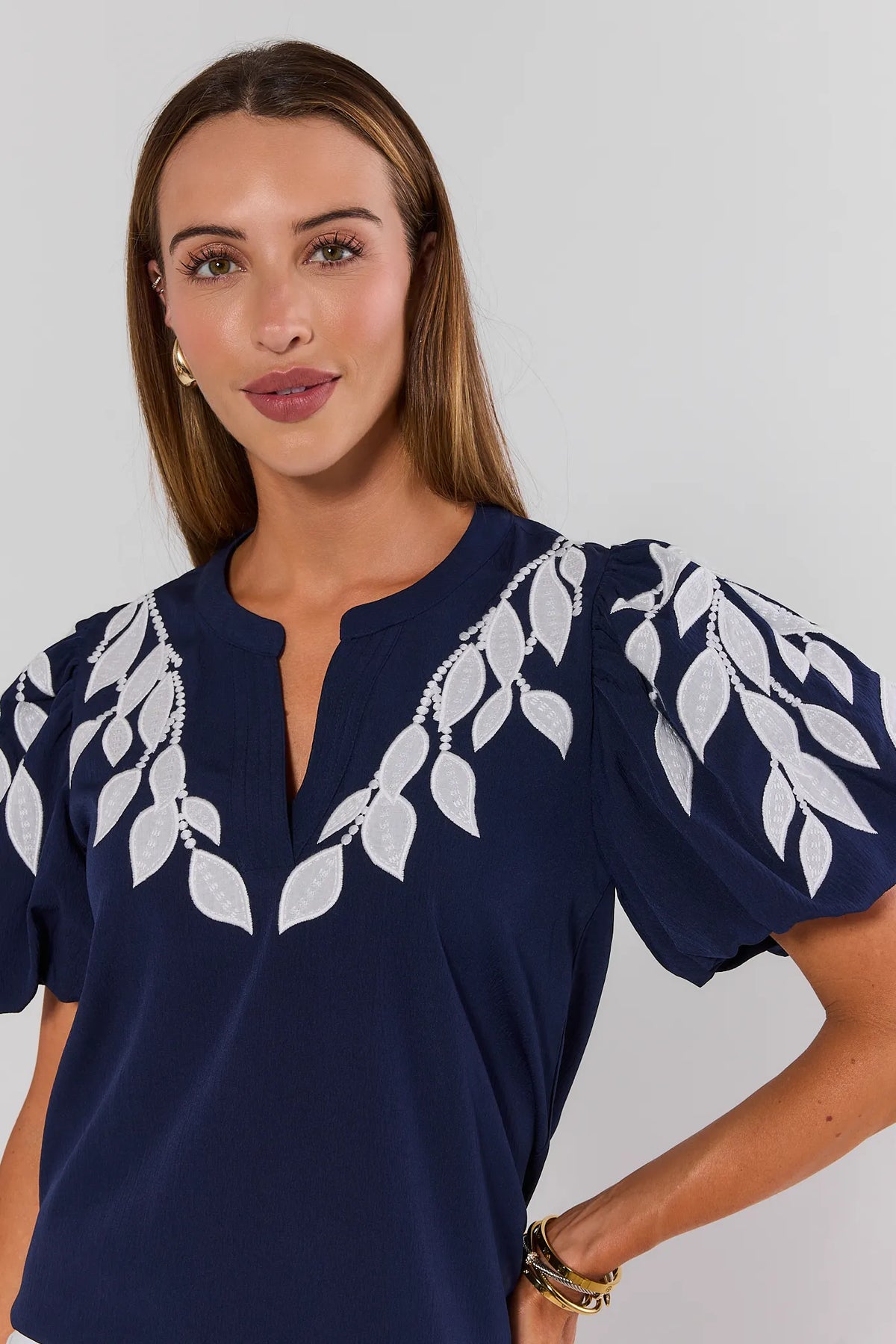 Beth Navy Embroidered Top close-up detail of white leaf embroidery and split neckline with puff sleeves | Avara
