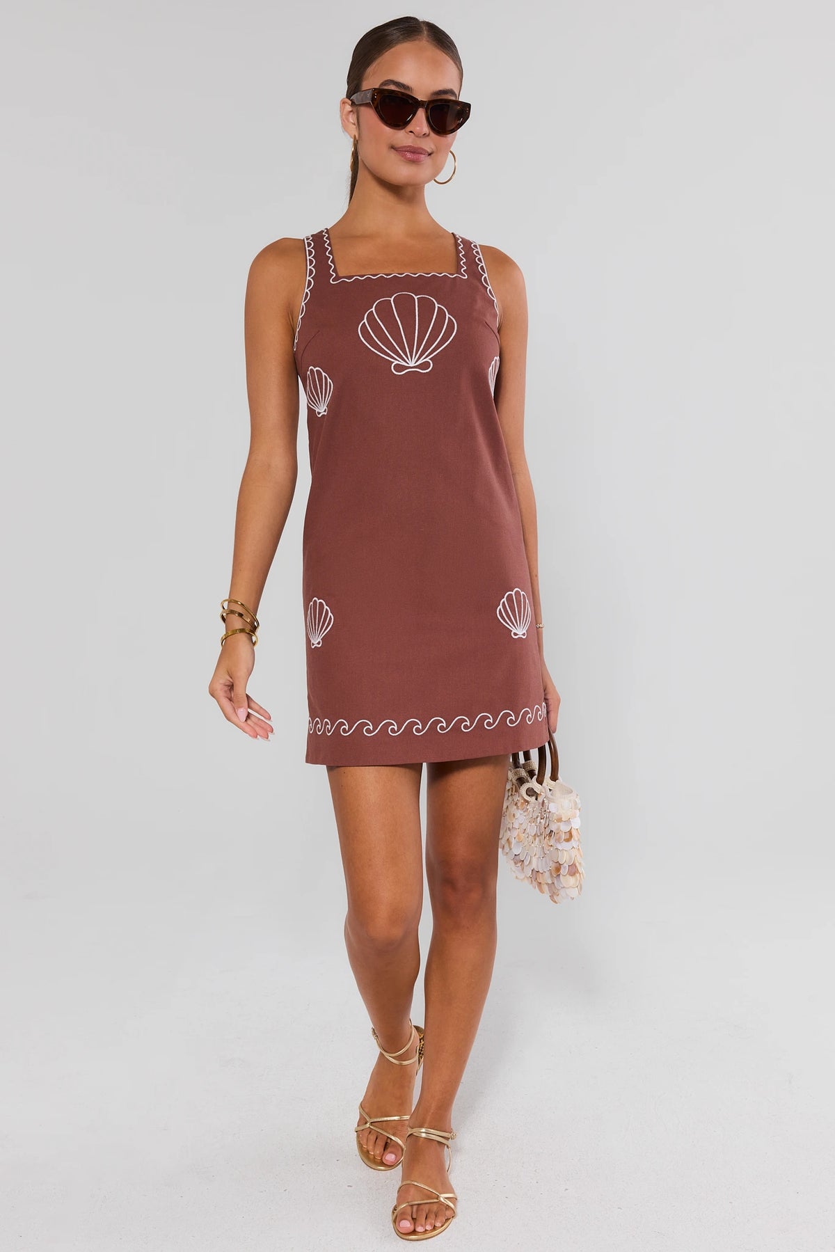 Woman in brown shell embroidered short dress styled with gold sandals and sunglasses, full-length | Avara