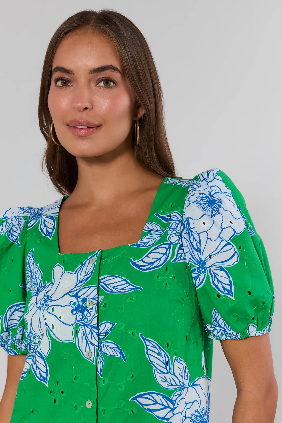 Close-up detail of green eyelet floral short dress neckline and puff sleeve with blue floral print | Avara