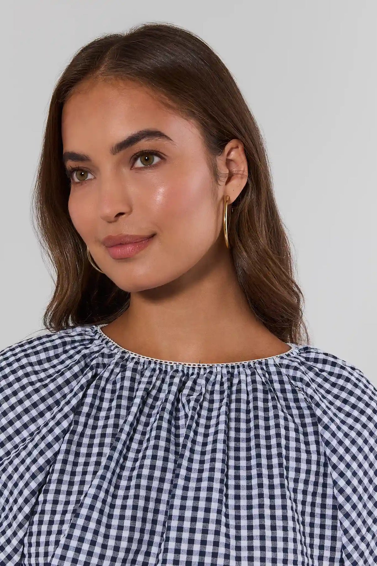 Navy Gingham Puff Sleeve Blouse gathered neckline close-up detail with gold hoop earrings | Avara