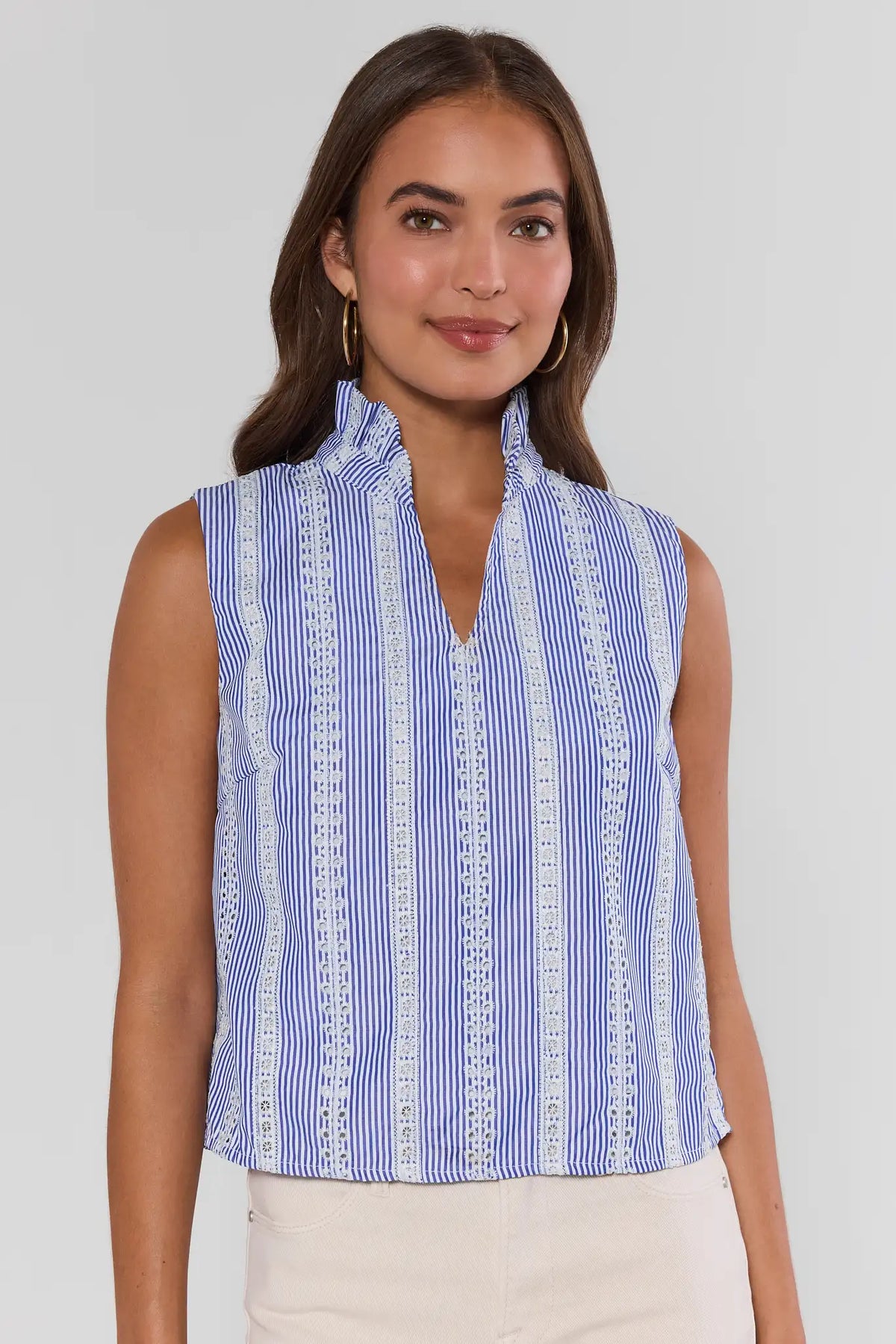 Woman wearing blue striped embroidered sleeveless top with cream skirt - Front View | Avara