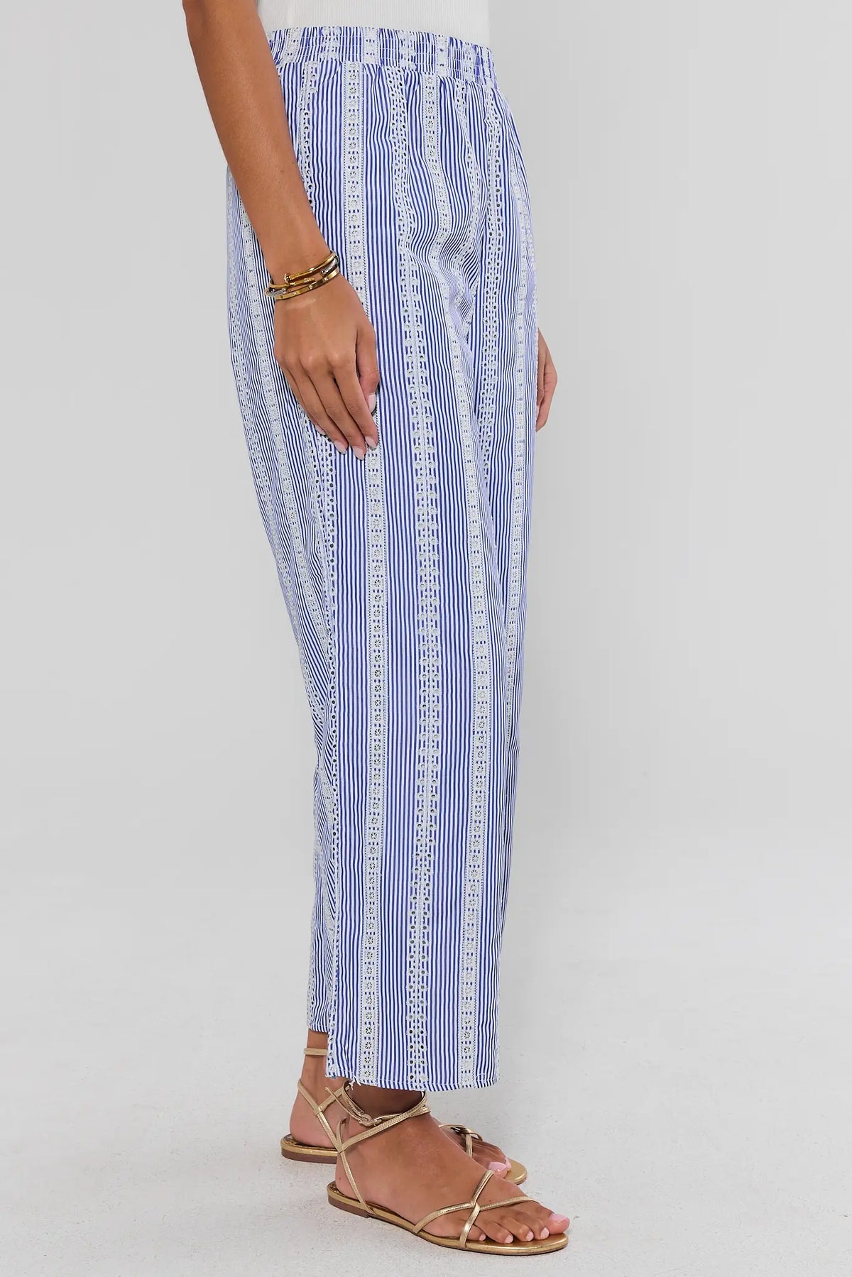 Blue stripe embroidered wide-leg pants showing elastic waistband detail, on model side profile view | Avara
