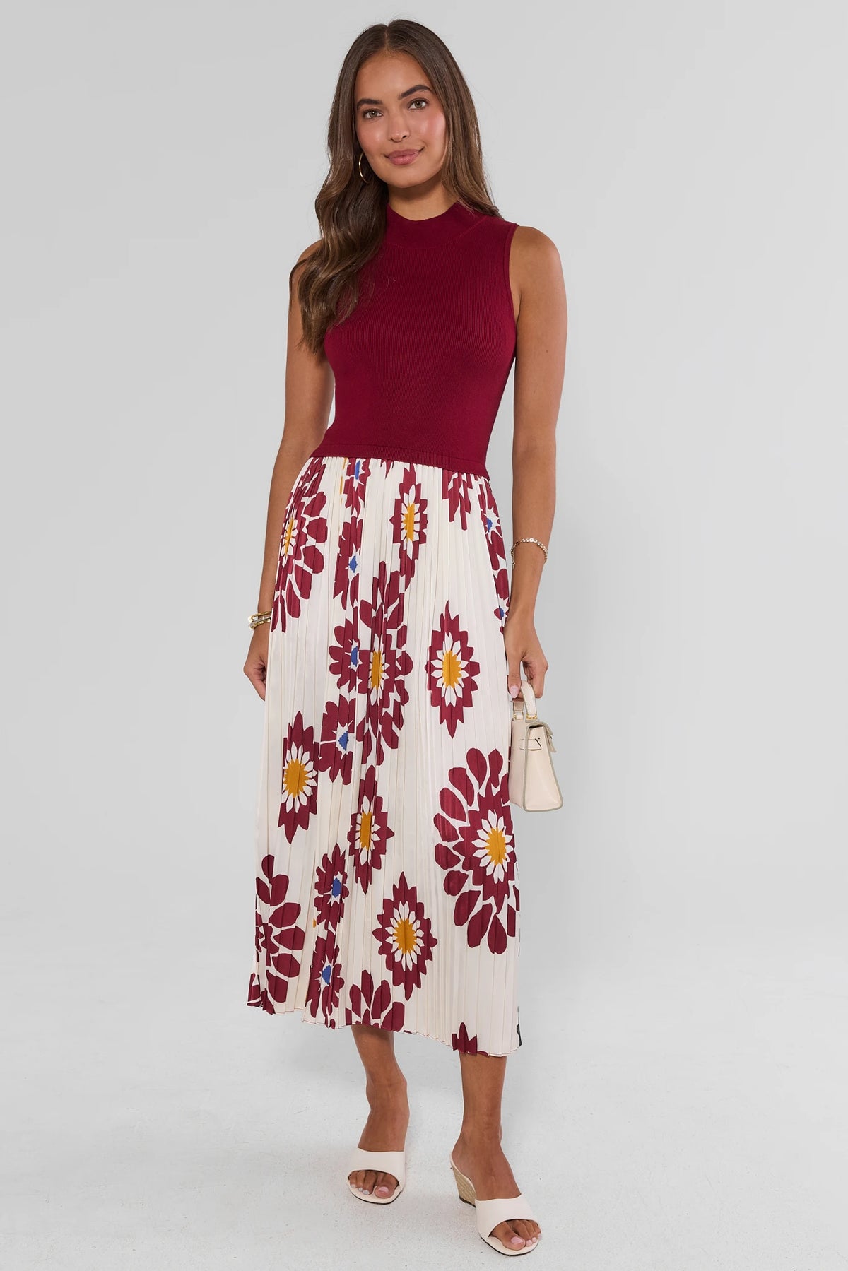 Woman standing in Marcia Burgundy Floral Midi Dress, front view, ribbed bodice and pleated skirt | Avara