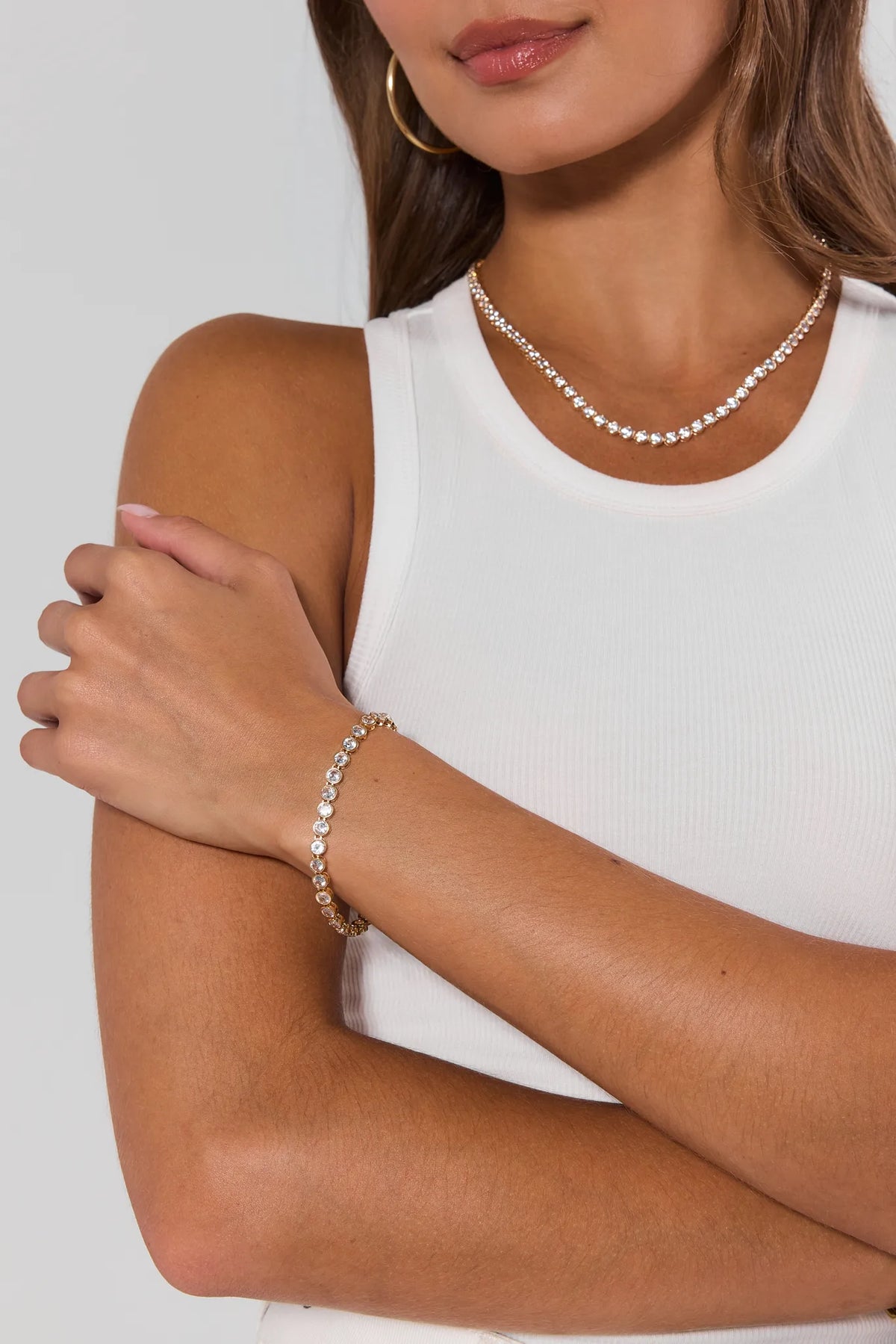 Woman wearing gold round bezel tennis bracelet and matching tennis necklace layered - On Model | Avara
