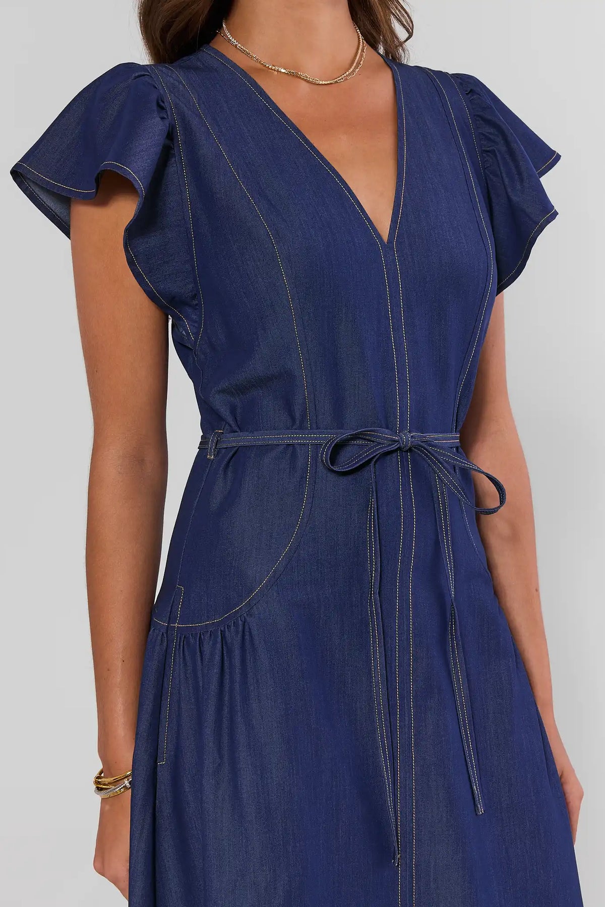 Dark blue denim flutter sleeve midi dress - flutter sleeve, tie waist, and contrast stitch close-up | Avara