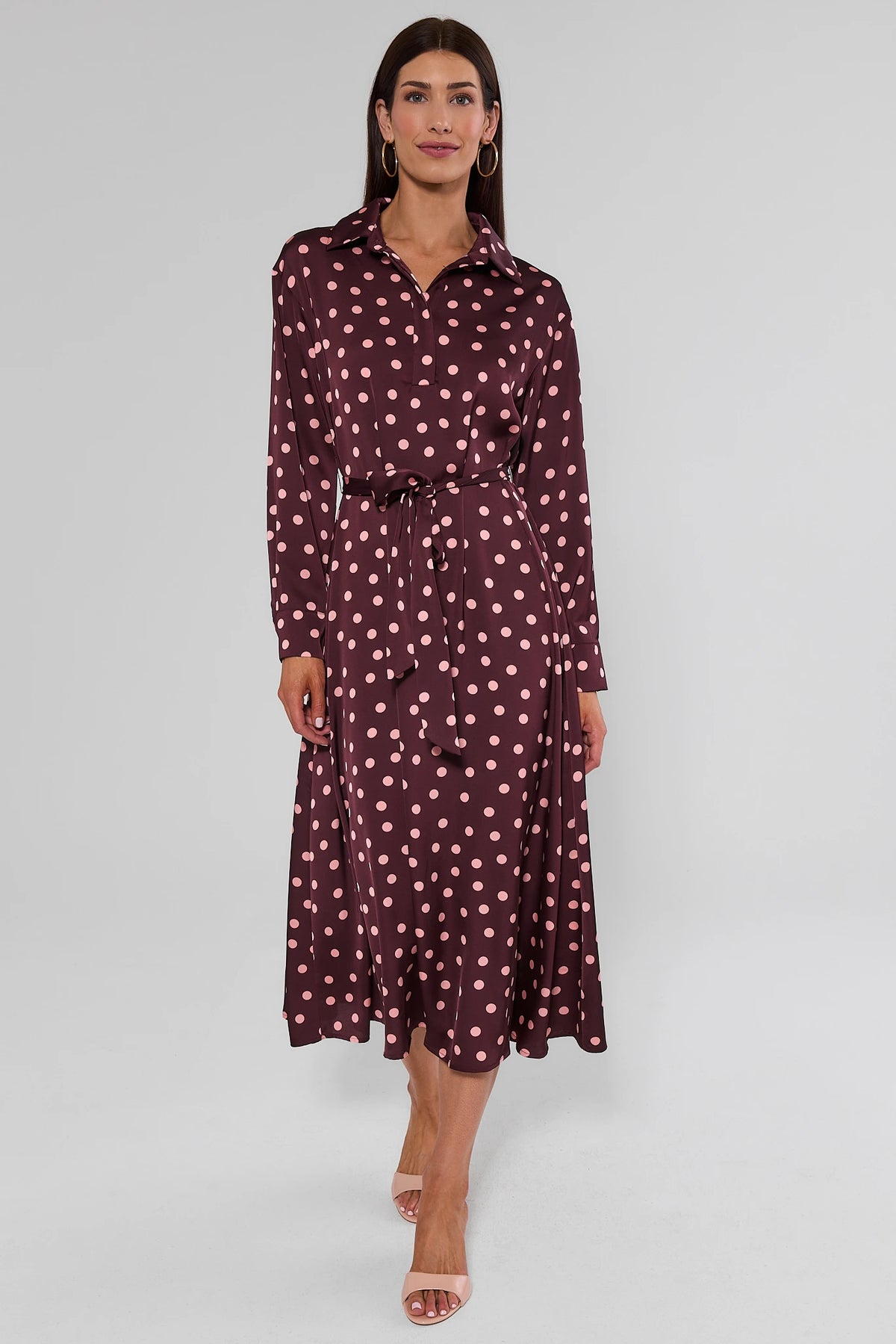 Woman in brown polka dot midi dress with long sleeves and flowy A-line skirt, full-length front view | Avara