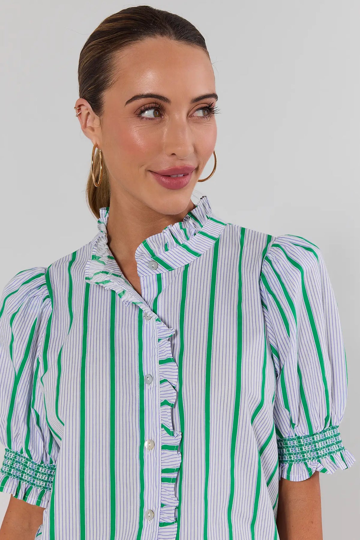 Close-up of green striped ruffle button-up top showing ruffle collar and smocked cuff detail | Avara