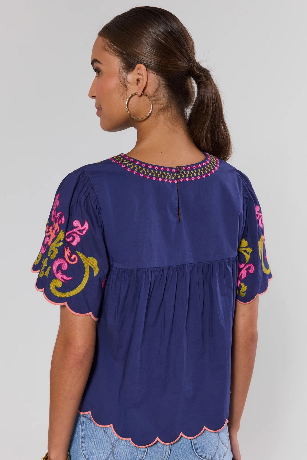 Back view of navy THML embroidered scalloped top showing scalloped hem and embroidered sleeves | Avara