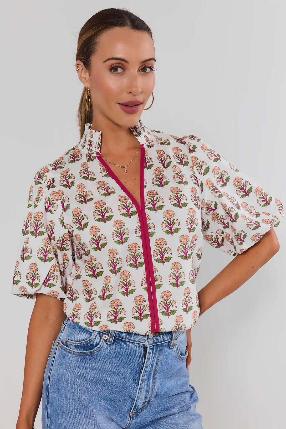 White Floral Printed Top by THML with puff sleeves and magenta zipper, paired with blue jeans - Side Angle View | Avara