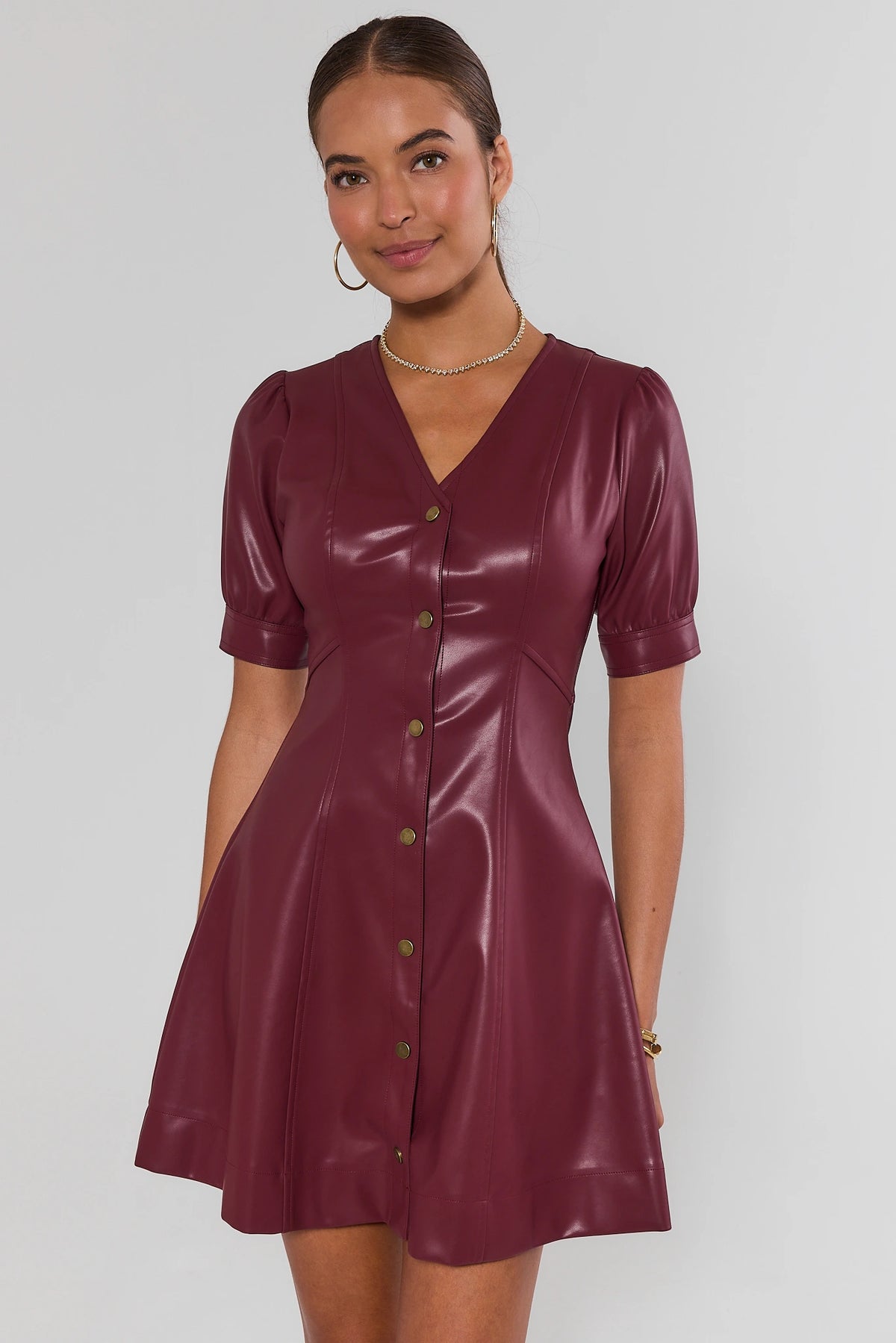 Burgundy faux leather short dress with puff sleeves, V-neckline, and gold buttons - Front View | Avara