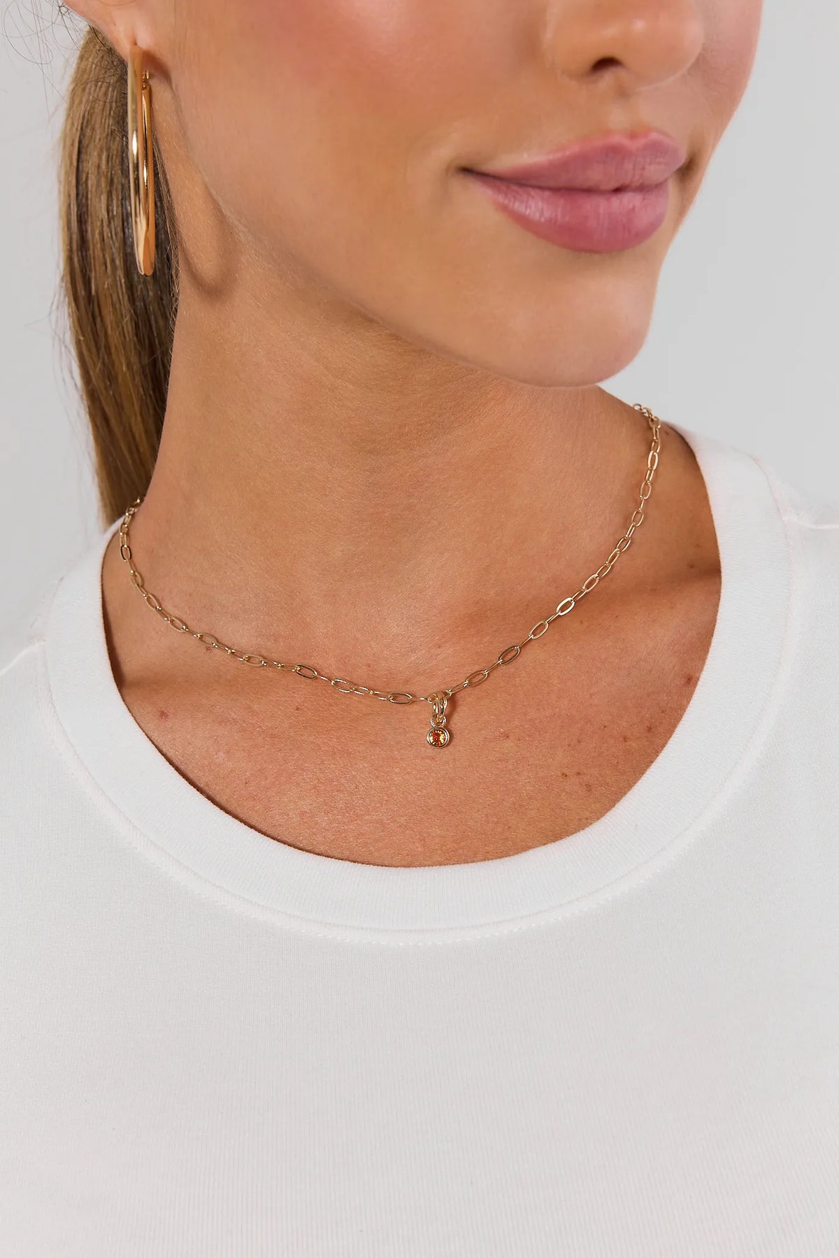 Orange rhinestone gold charm on gold chain necklace styled on model - game day accessories | Avara