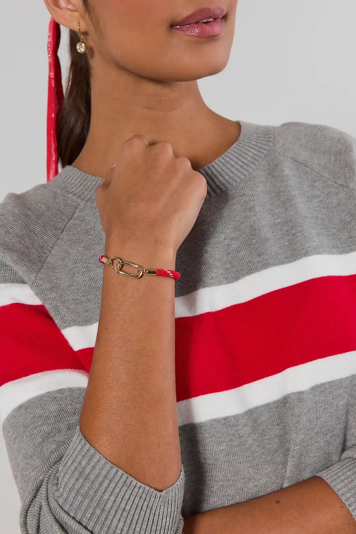 Red carabiner cord bracelet with gold clasp worn on model's wrist - On Model | Avara