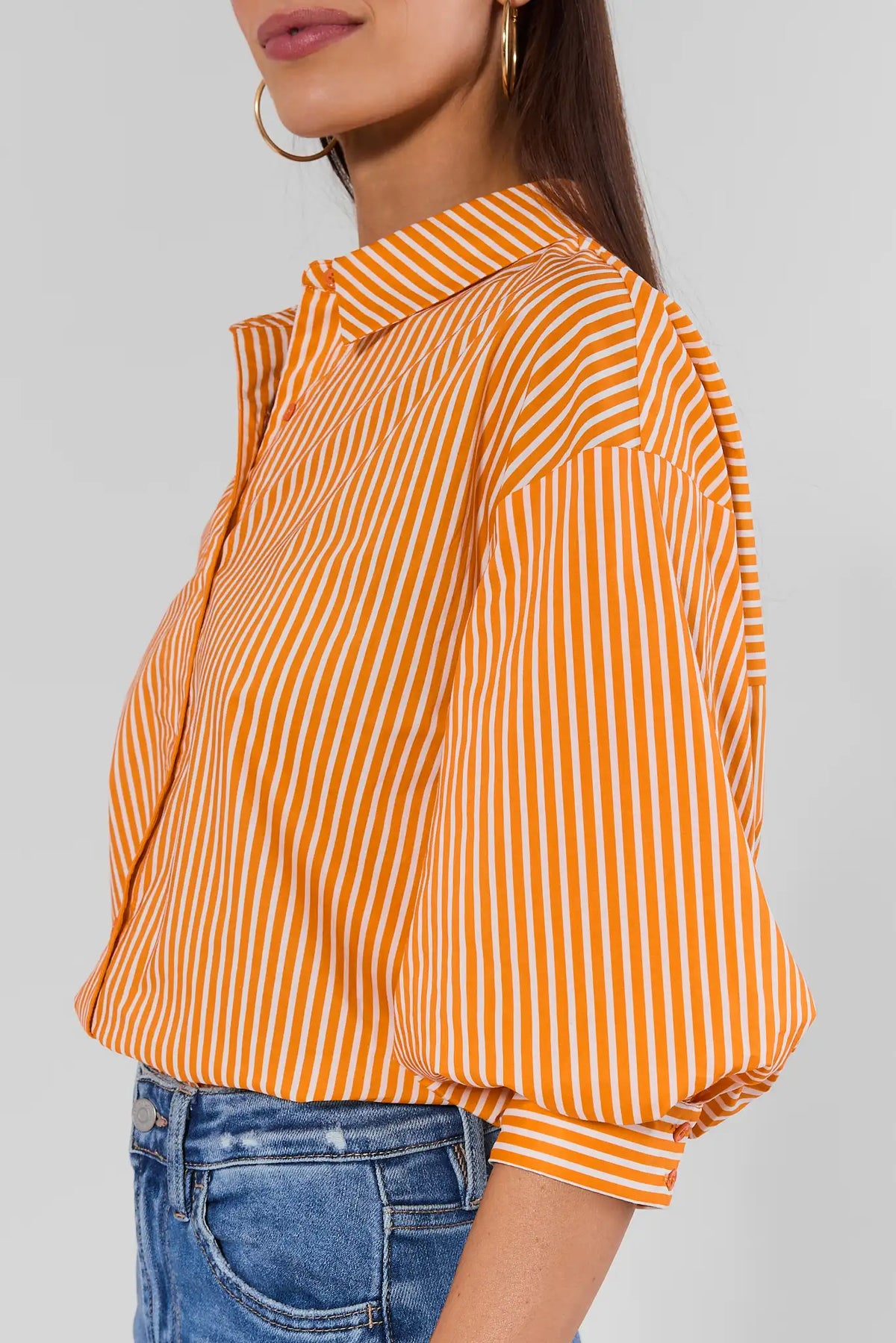Orange and white striped button-up top with puff three-quarter sleeves - Side Profile View, styled with jeans | Avara
