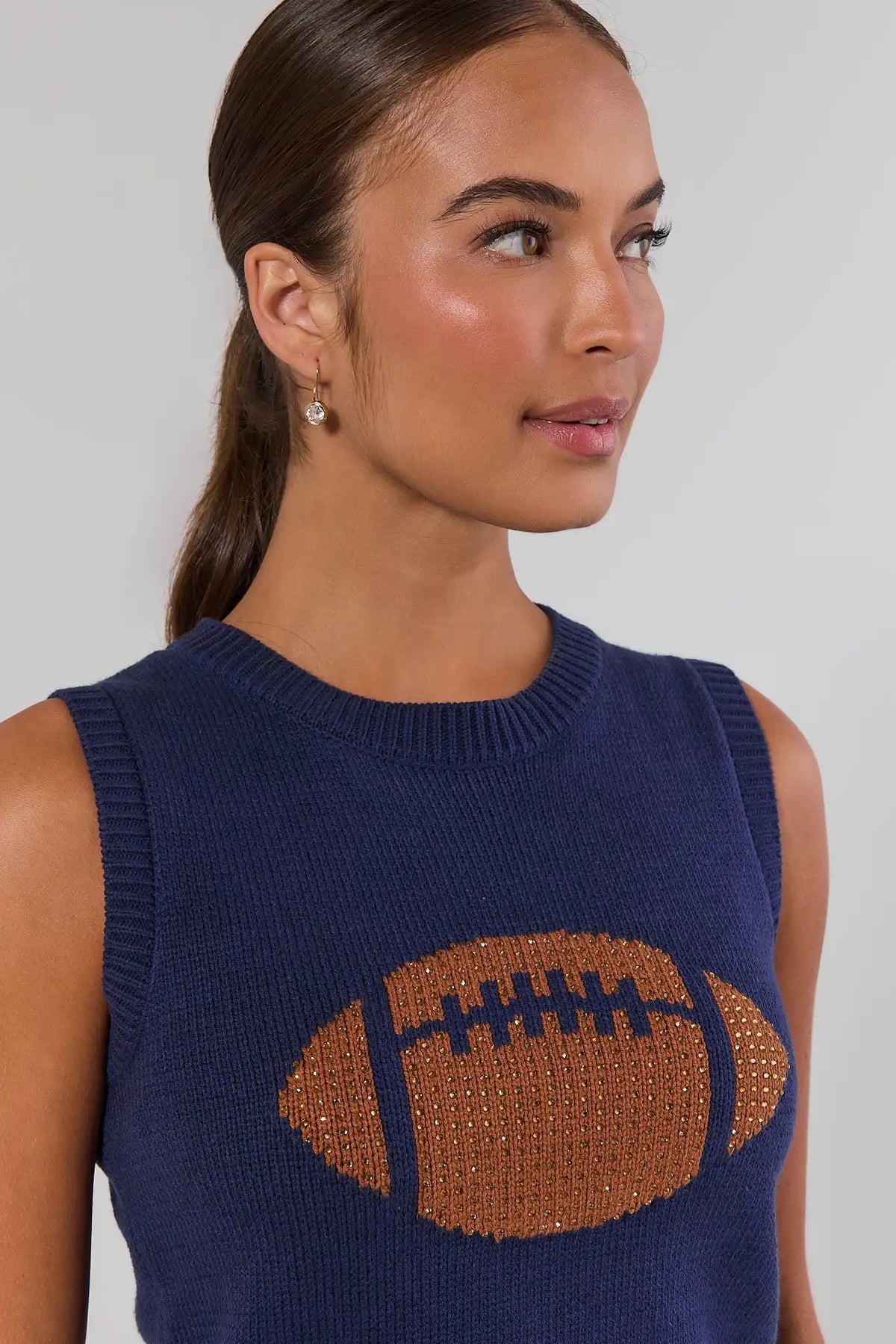 AJ Navy Football Sleeveless Knit Top rhinestone football close-up, crew neckline and ribbed trim - Detail View On Model | Avara