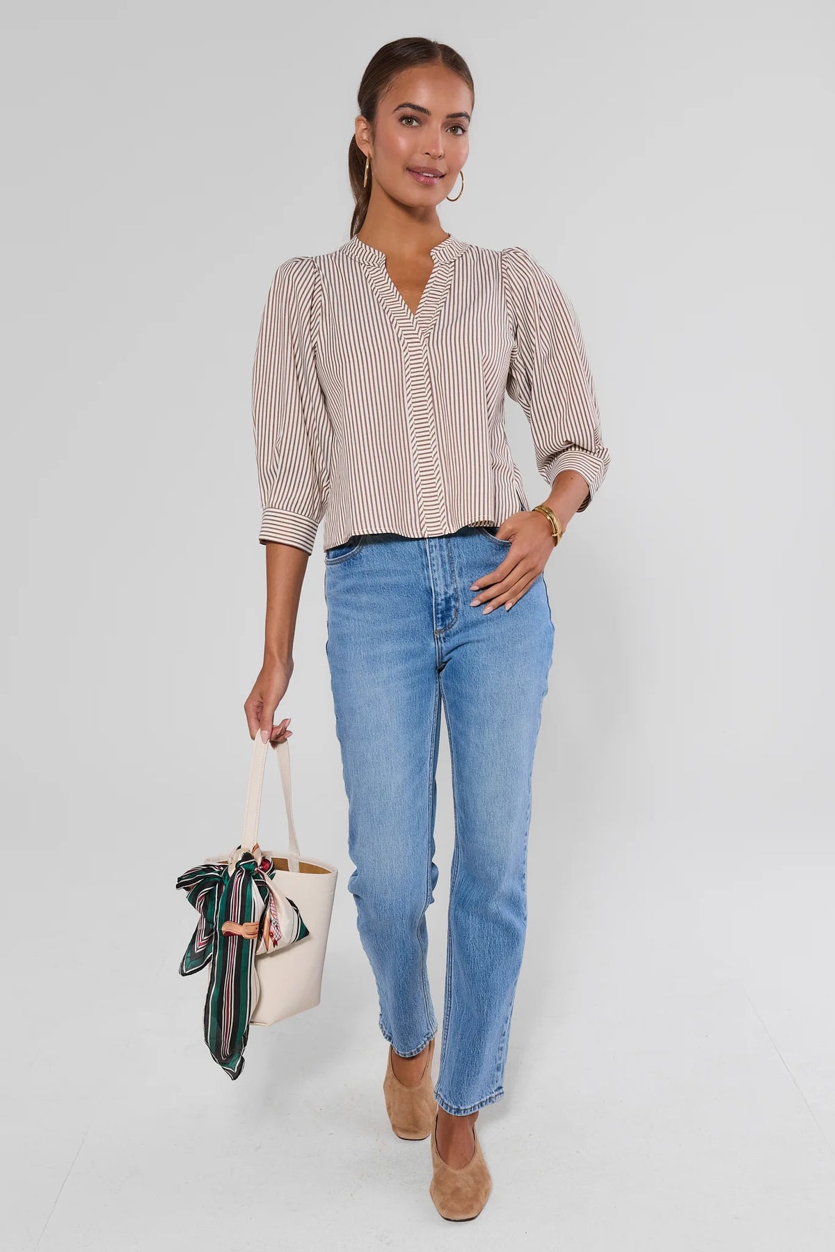 Thea Brown Striped Top styled with light-wash jeans, tote bag, and tan heels - Full Outfit View | Avara