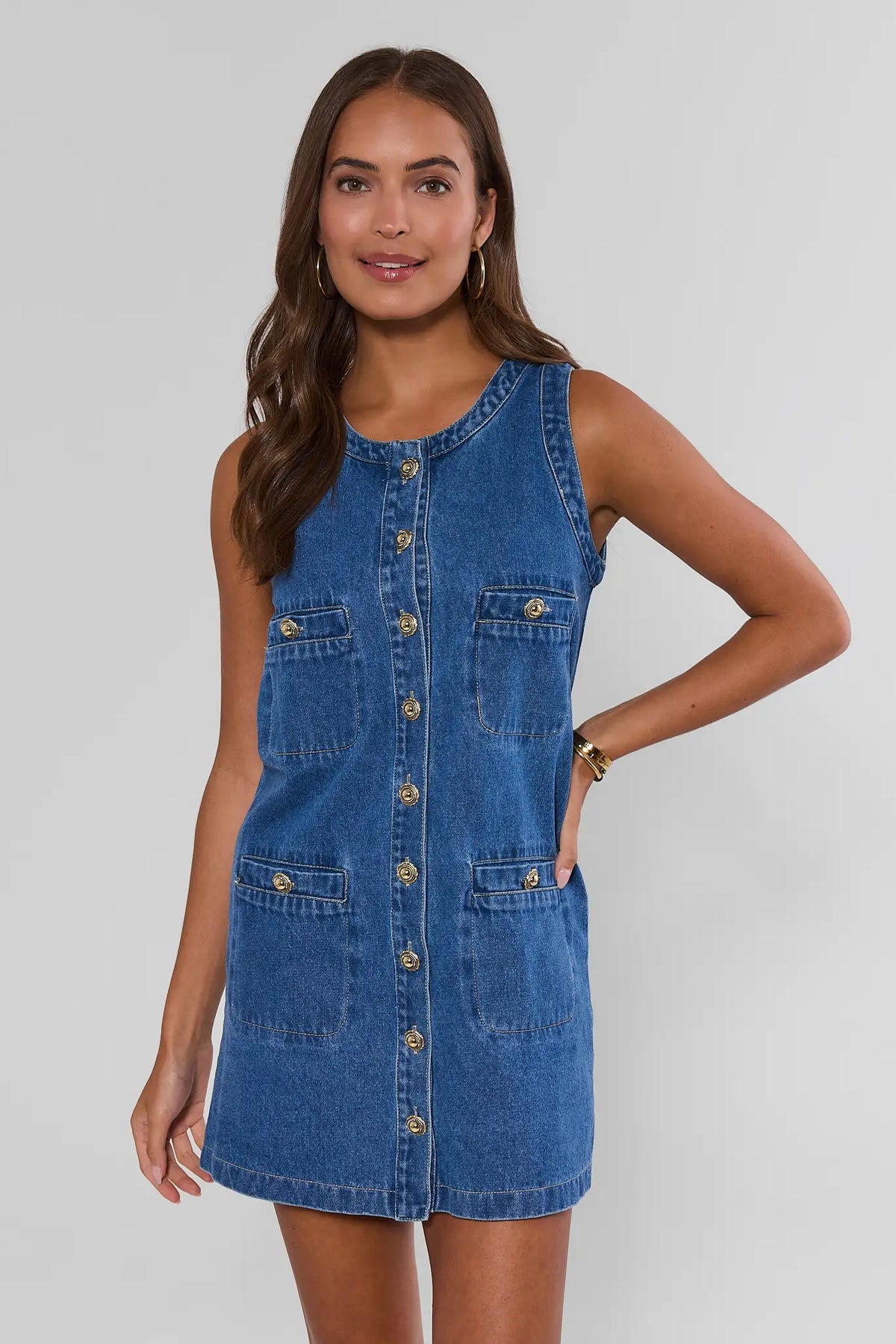 Blue denim button-up short dress with gold buttons and four patch pockets - Front View | Avara