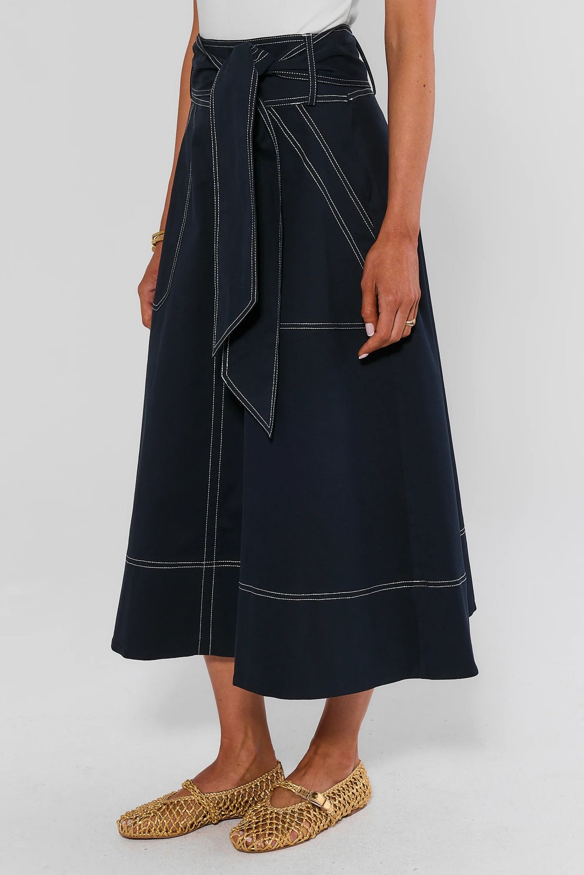 Navy Charlotte Tie Waist Midi Skirt with white contrast stitching - Side View showing A-line silhouette | Avara