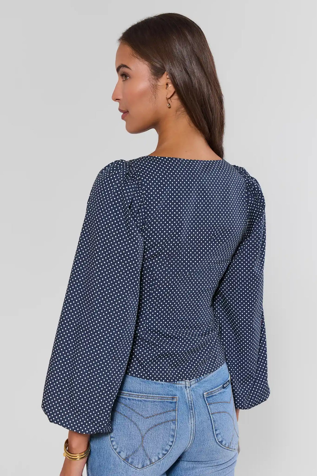 Navy white polka dot puff sleeve top back view showing balloon sleeve detail, paired with blue jeans | Avara