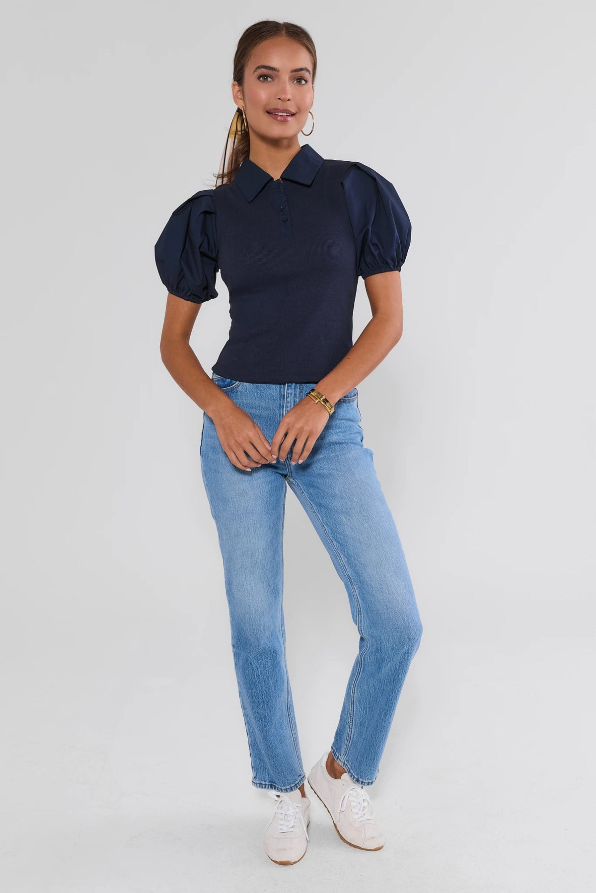 Navy puff-sleeve polo top full-length front view paired with light wash straight-leg jeans and white sneakers | Avara