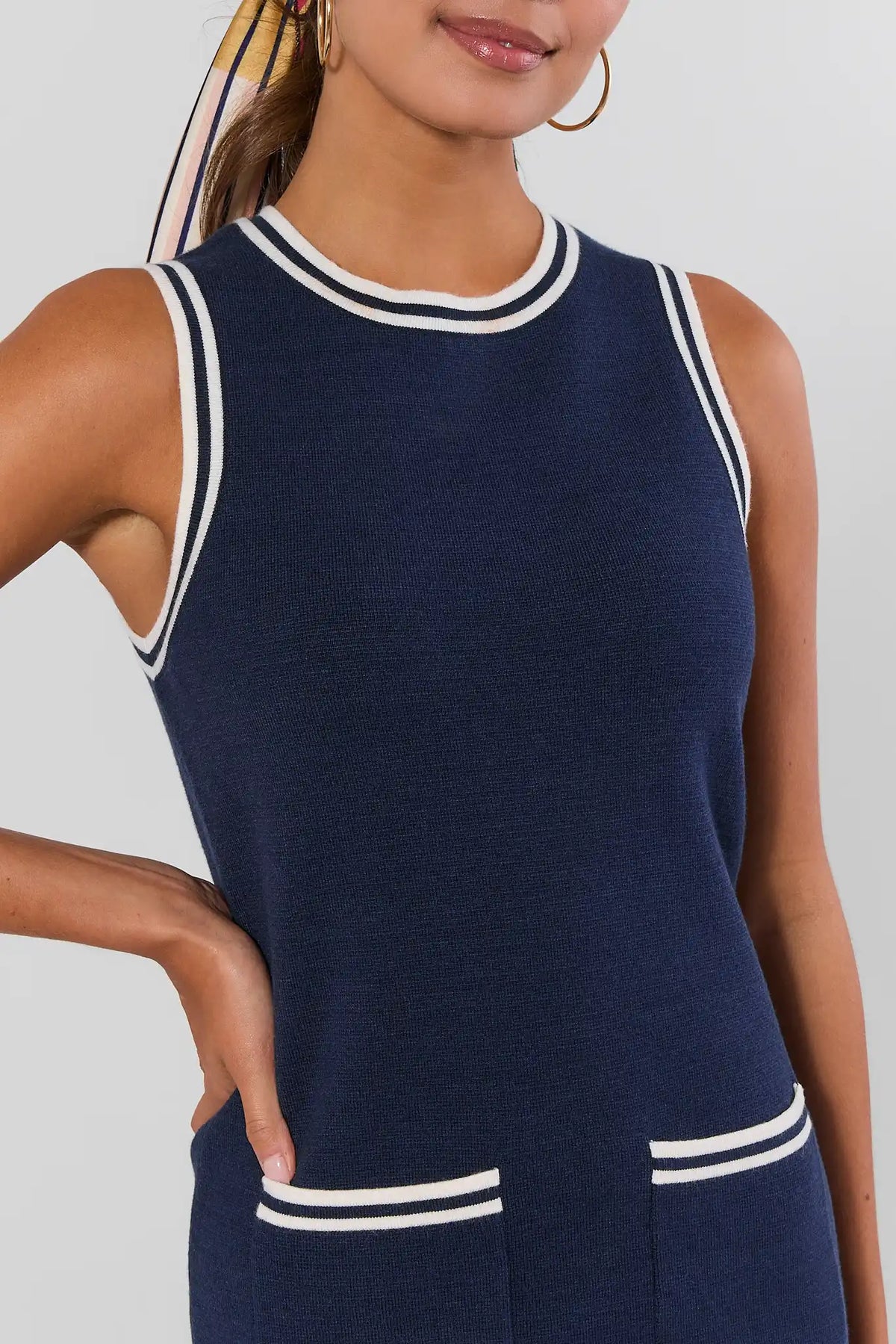 Close-up of navy striped trim dress neckline and pocket detail with white contrast tipping, front torso view | Avara