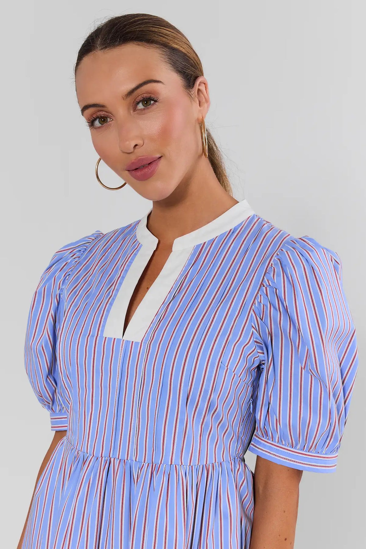 Close-up of white split neckline and puff sleeve detail on blue striped short dress for women | Avara