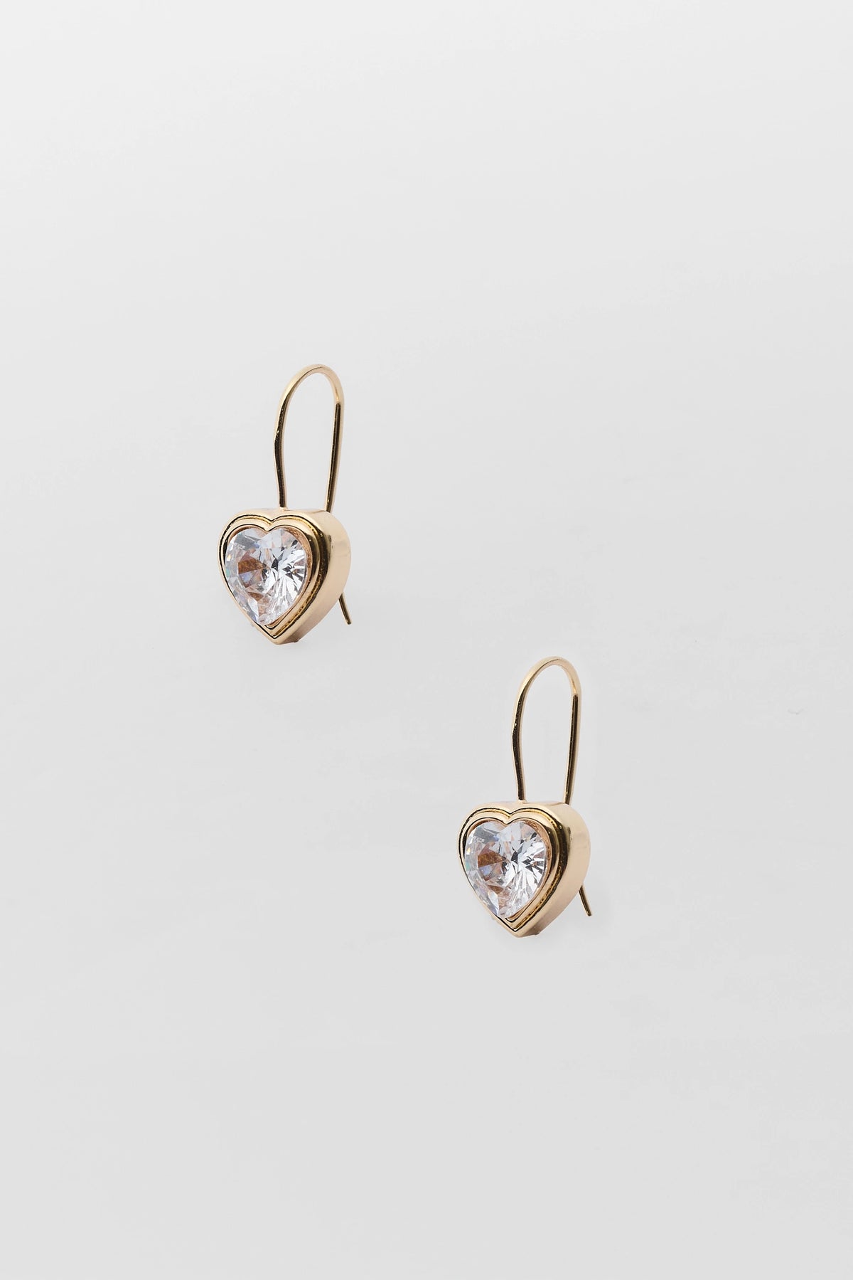 Gold heart rhinestone drop earrings with clear crystal centers, bezel-set - Flat Lay | Avara