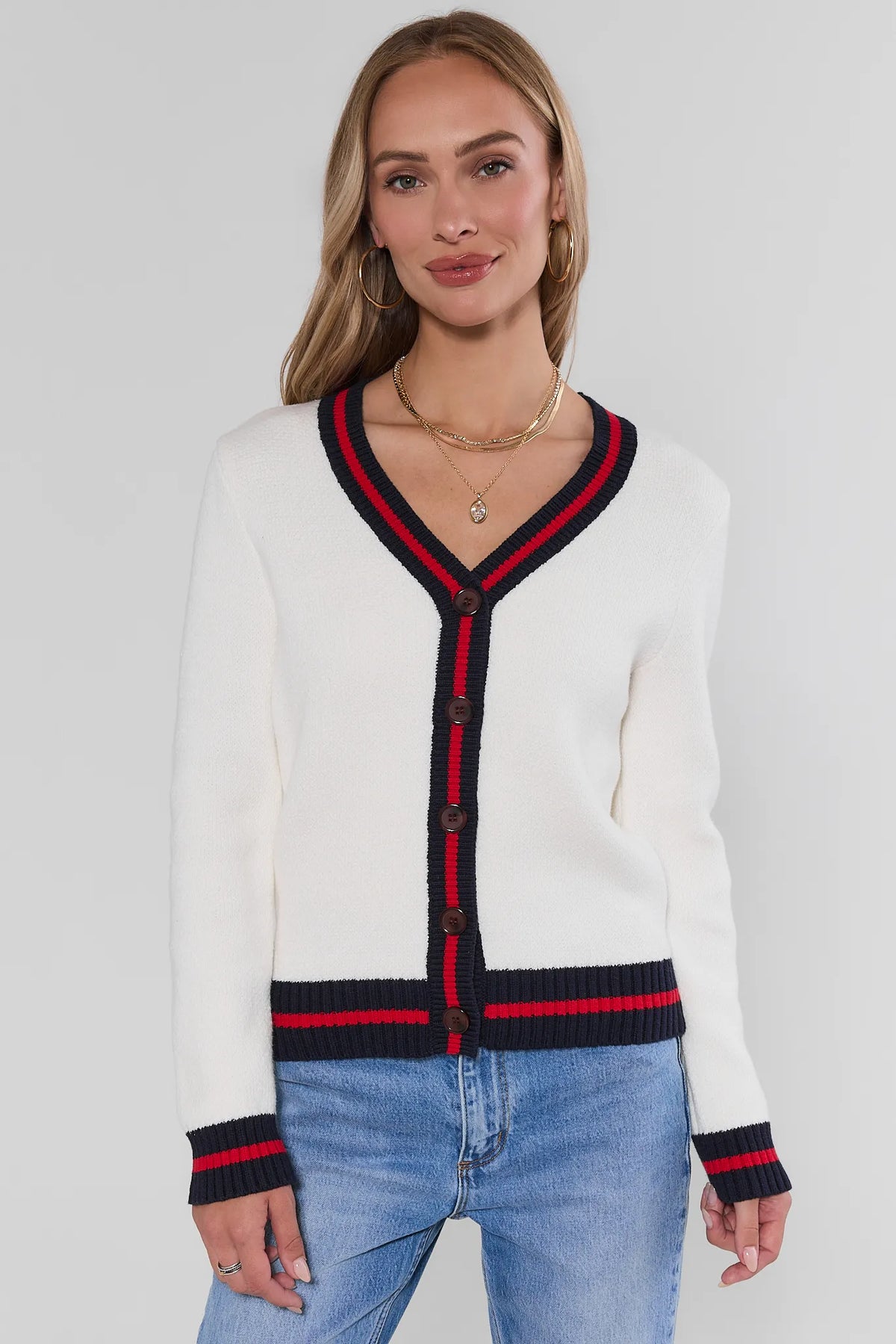 White knit cardigan with navy and red striped trim at V-neck, buttons, cuffs, and hem - Front View | Avara