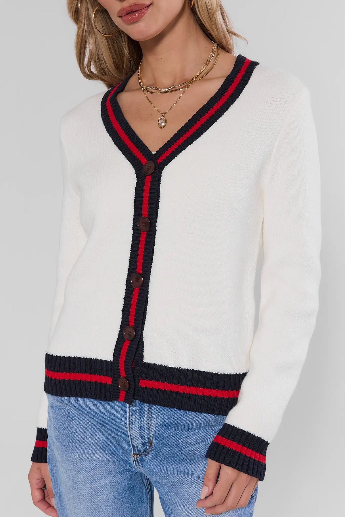 White striped trim cardigan with navy and red V-neck and button placket detail, paired with jeans - Close-Up | Avara