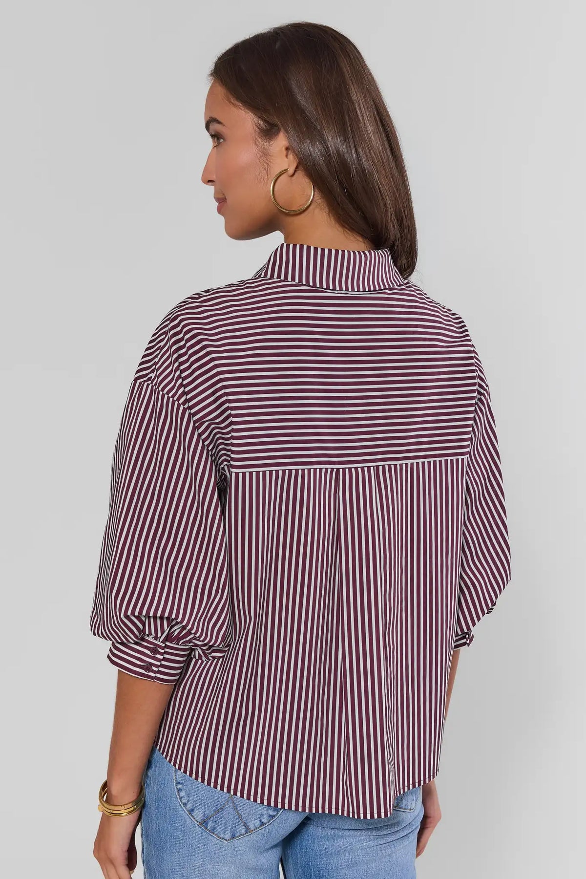 Back view of burgundy and white striped button-up blouse with puff sleeves and yoke detail | Avara