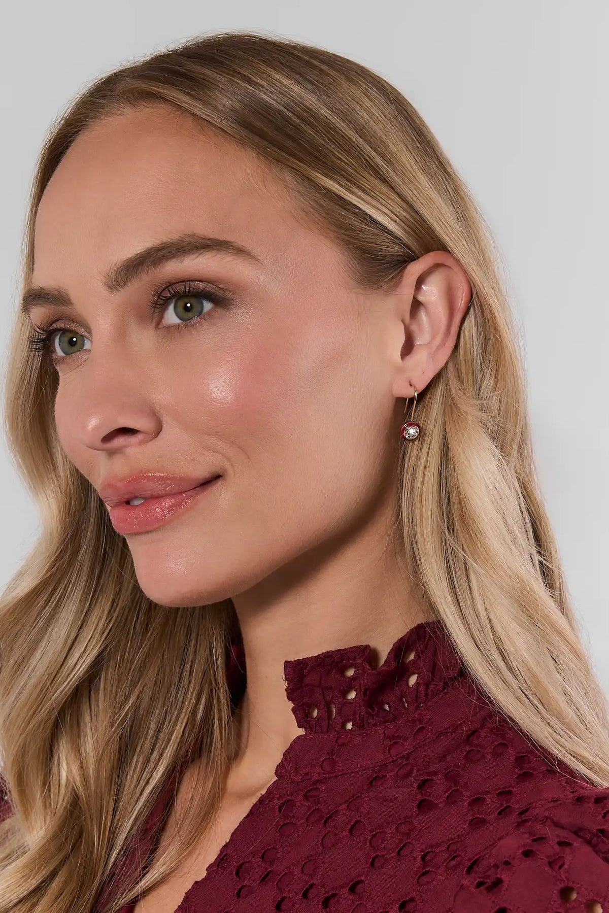 Maroon round rhinestone drop earrings on model with burgundy eyelet top - side profile | Avara