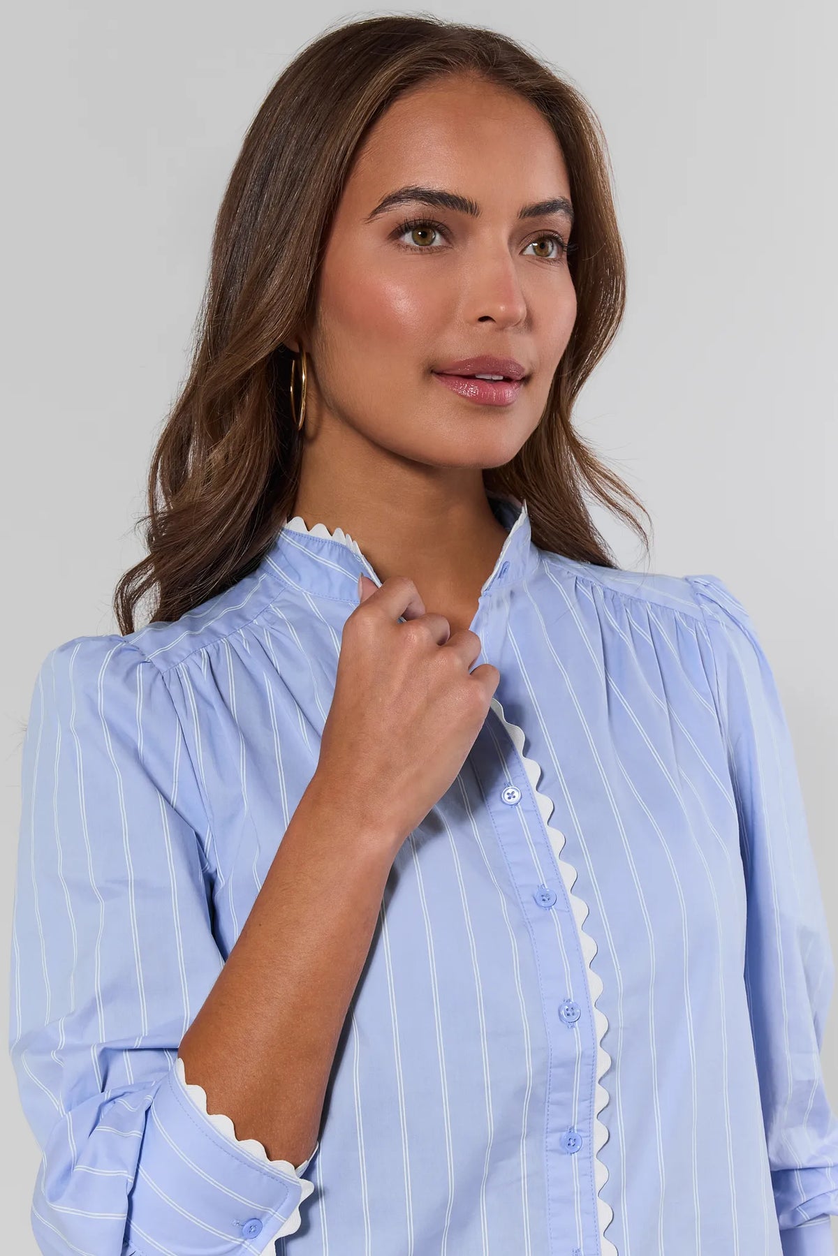 Close-up of white ric rac trim along band collar and button placket on blue striped top - Detail View | Avara