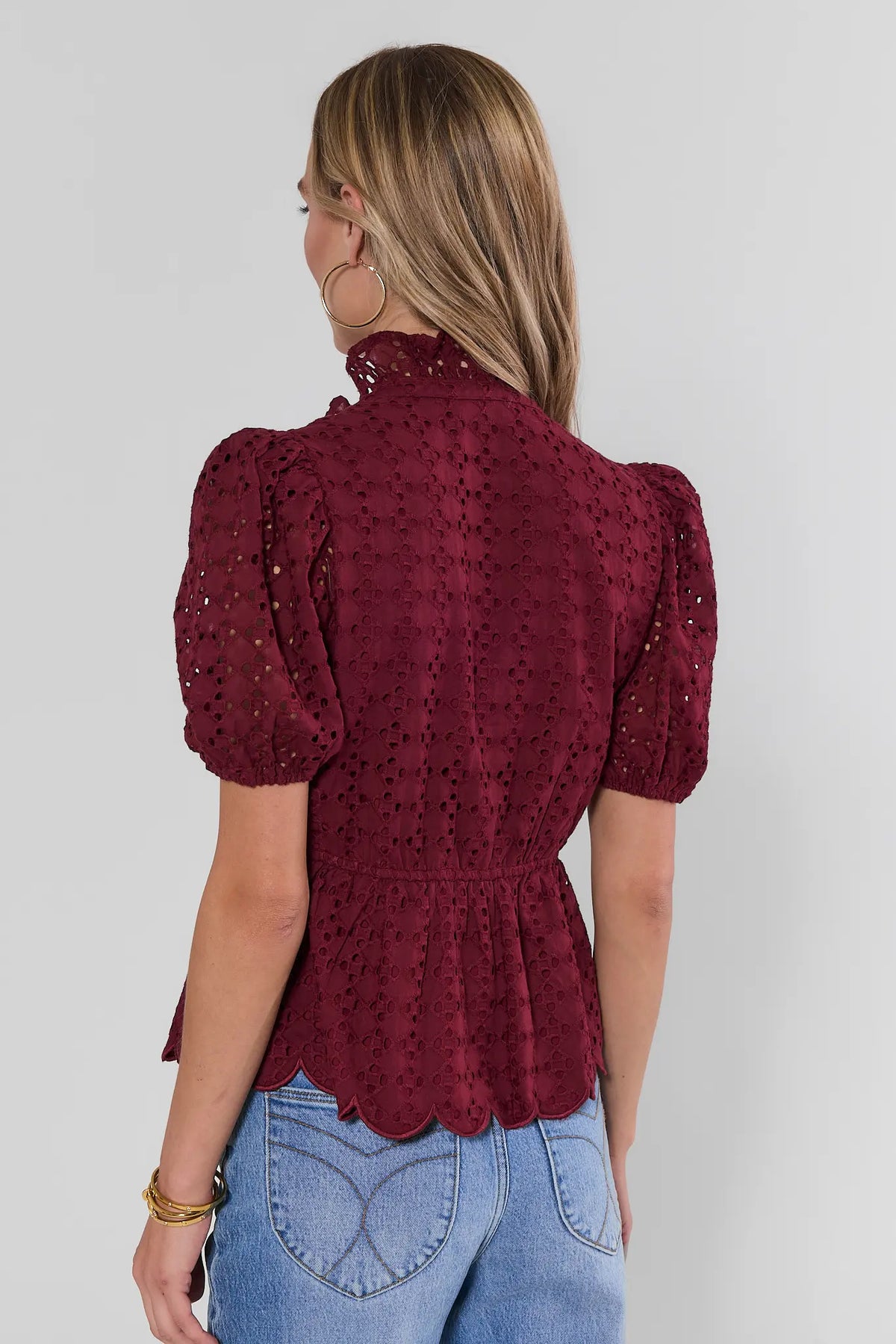 Maroon eyelet peplum top showing ruffle collar, puff sleeves, and scalloped hem detail - Back View | Avara