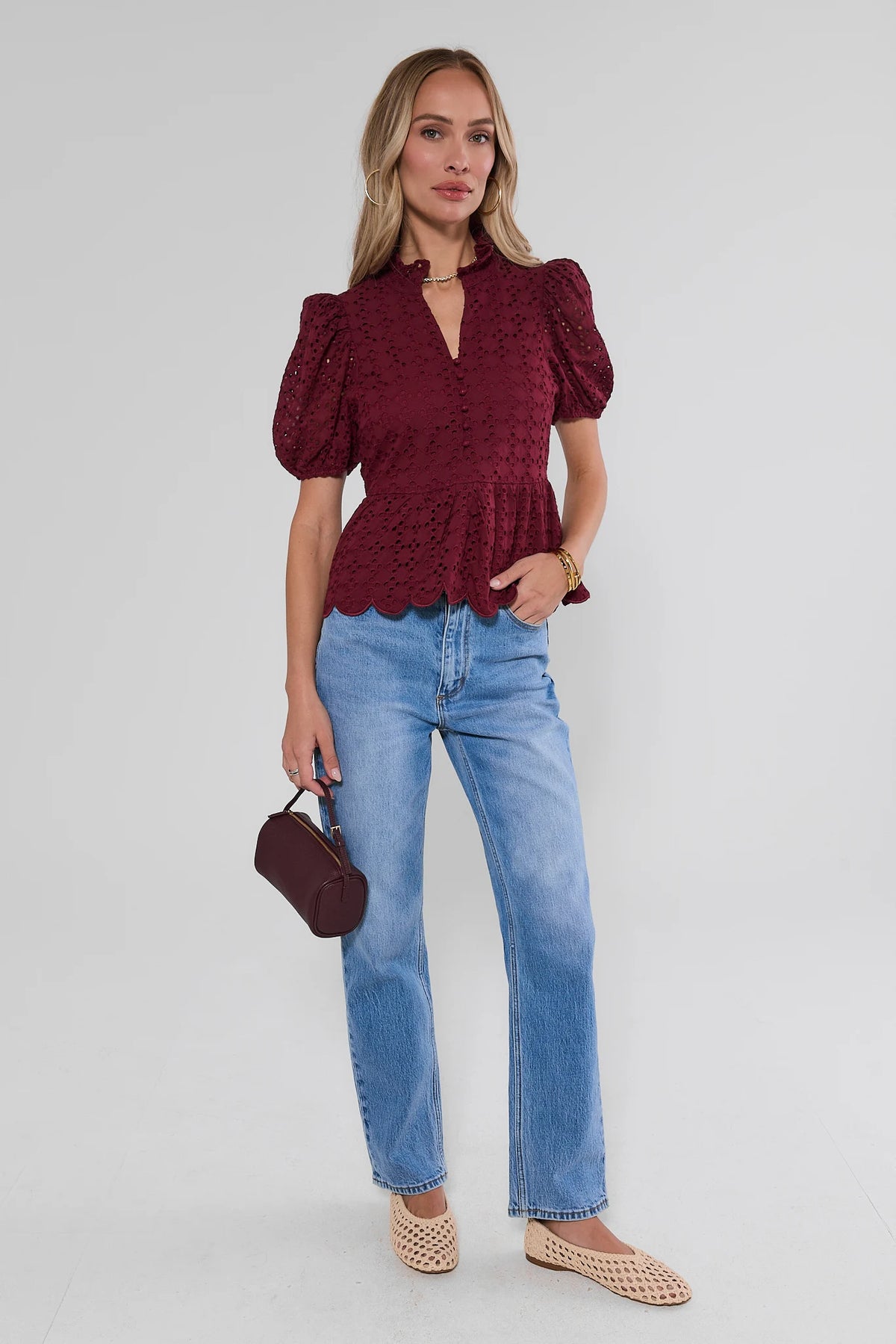 Maroon eyelet peplum top styled with straight-leg jeans, burgundy mini bag, and woven flats - Full Length View | Avara
