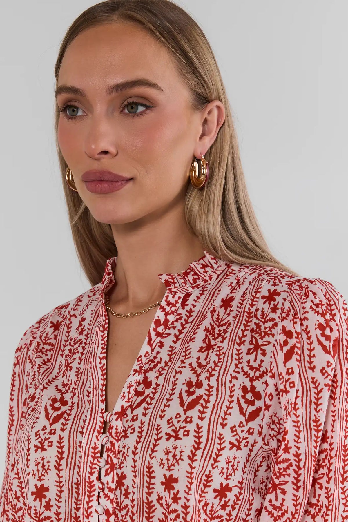Close-up of Red Floral Printed Button Up Top neckline detail with gold hoop earrings and chain necklace | Avara