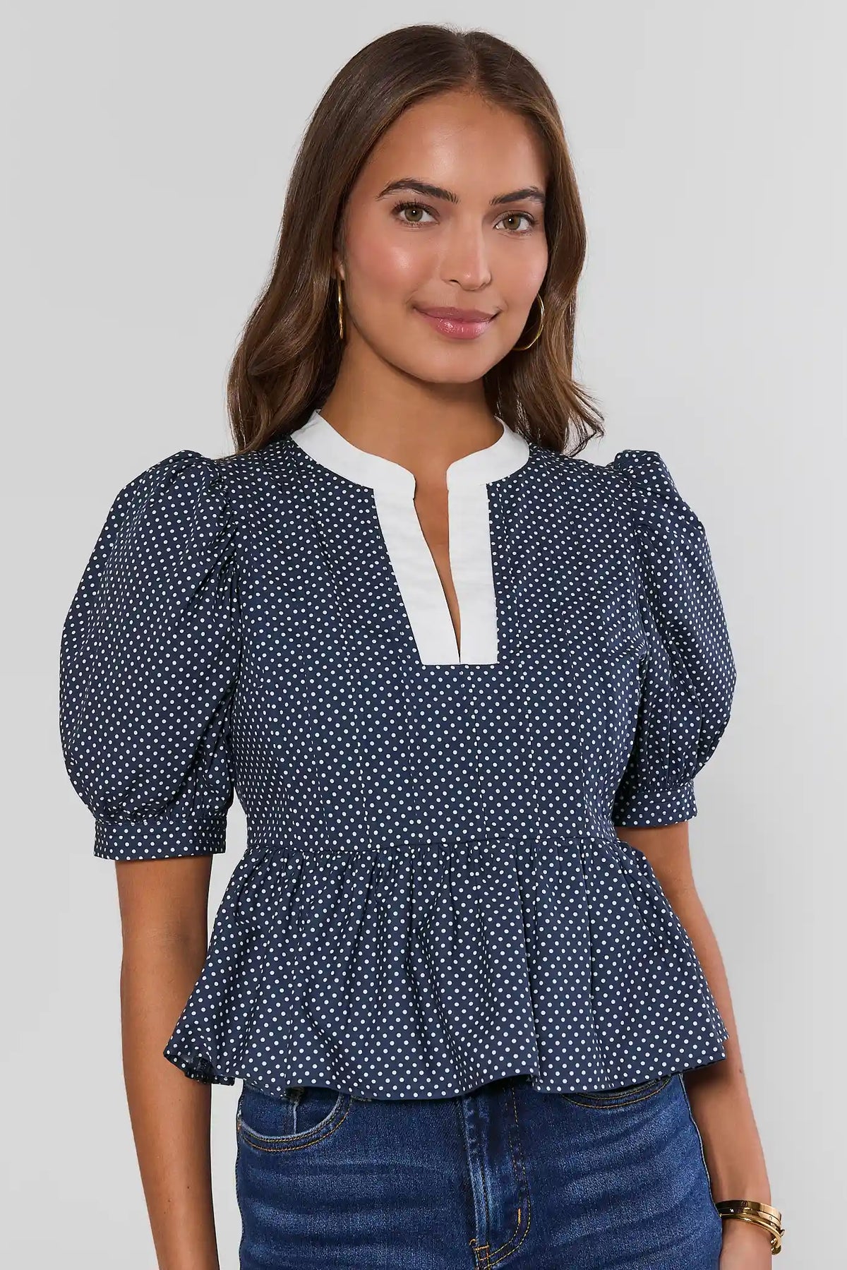 Navy Polka Dot Peplum Top with White Contrast Neckline - Front View On Model | Avara