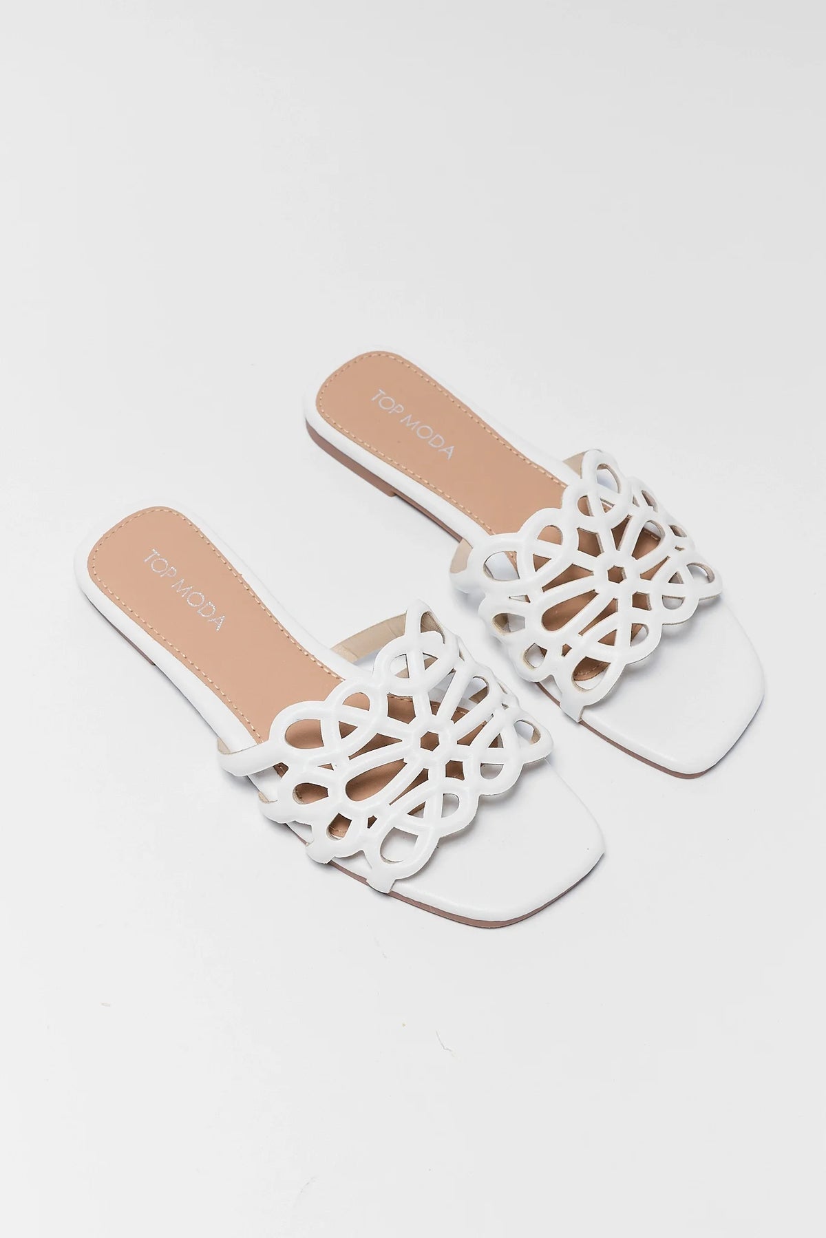 White cutout floral sandals pair - front toe view showing floral cutout strap detail | Avara