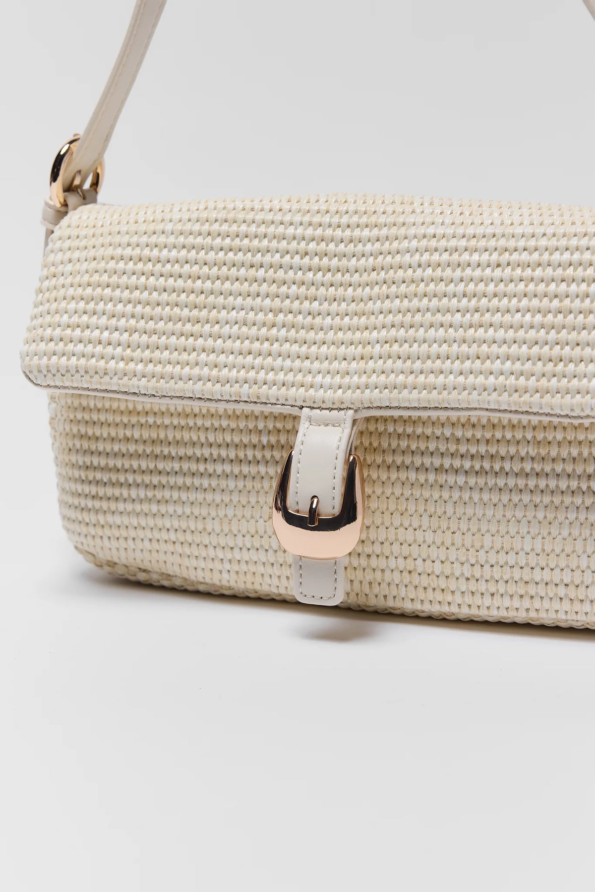 White raffia handbag close-up showing woven texture and gold buckle hardware detail - Detail View | Avara
